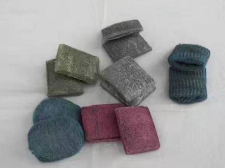 Es handelt sich um aus miteinander verwickelten Stahldrähten (max. Querschnittsabmessung: weniger als 0﻿,﻿1 mm), sog. Stahlwolle, gefertigte Schwämme in verschiedenen Formen, die mit einem farbigen Seifenpulver überzogen sind. 
Die Erzeugnisse sind zu jeweils acht Stück in einem bedruckten Pappkarton verpackt und dienen dem Reinigen von z. B. Töpfen.
- Antragstellerangaben -

Abbildung siehe Anlage.

Der Charakter der aus verschiedenen Stoffen bestehenden Erzeugnisse wird aufgrund der Bedeutung für die Verwendung und des Umfangs durch die Stahlwolle bestimmt.

Derartige Erzeugnisse gehören als "Schwämme aus Stahlwolle, zum Scheuern, Polieren oder dergleichen" zum TARIC-Code 7323 1000 00.