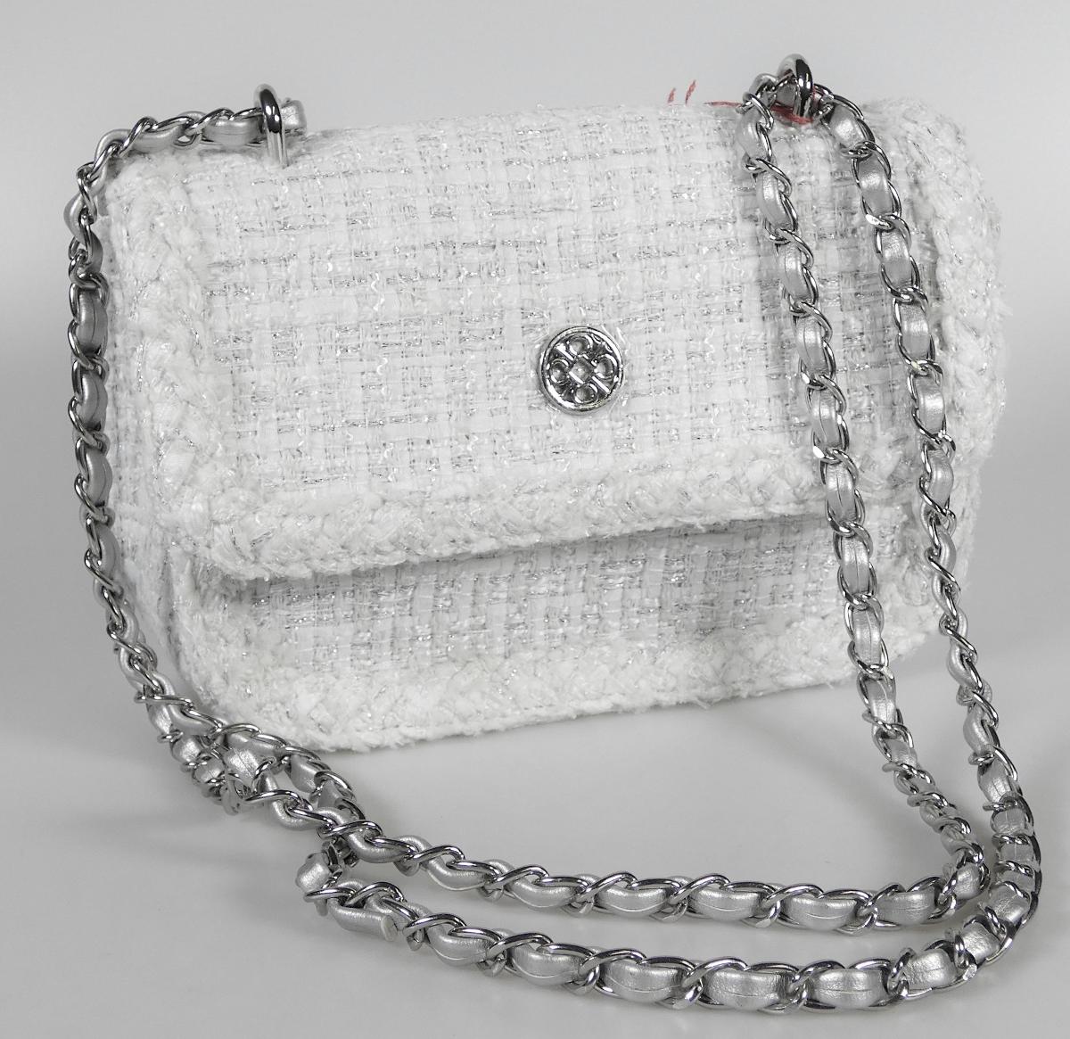 Handtasche, Foto siehe Anlage,
- mit einer Außenseite aus Spinnstoffen,
- mit einem Schultertrageriemen in Form einer Gliederkette aus unedlem Metall mit einem
  eingearbeiteten Streifen aus Kunststofffolie,
- mit einer Überschlagklappe mit einem magnetischen Druckknopfverschluss,
- - gefüttert; innen mit einem offenen Einsteckfach ausgestattet,
- mit den Abmessungen: ca. 20 cm (Breite) x 14 cm (Höhe) x 7 cm (Tiefe),
- laut Antrag nicht handgearbeitet,
- Handtasche, da aufgrund der Größe und des Gesamteindrucks in erster Linie dazu geeignet,
  kleinere, persönliche Gegenstände aufzunehmen.

"Handtasche, mit Außenseite aus Spinnstoffen, nicht handgearbeitet"