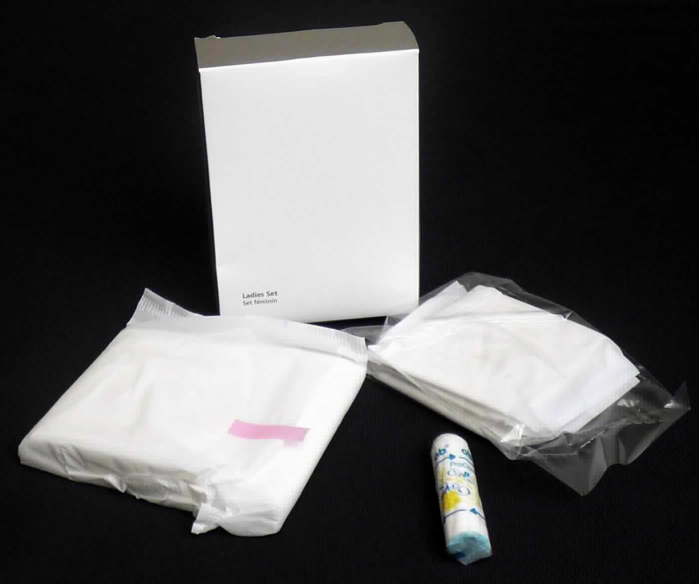 Es handelt sich um eine Zusammenstellung der nachfolgend beschriebenen Waren, die gemeinsam in einer mit warenbezogenen Hinweisen bedruckten Pappschachtel verpackt sind:

- Drei mehrlagige, weiche, jeweils auf eine Kunststofffolie aufgebrachte Damenbinden mit folgendem Lagenaufbau:
-- eine Außenlage aus einem Vliesstoff aus Spinnstofffasern,
-- eine weiche, watteähnliche Sauglage aus Zellstofffasern mit beigemischtem absorbierendem Granulat,
-- eine Außenlage aus geprägter Kunststofffolie, auf die mittig Klebestreifen zur Fixierung im Slip aufgebracht sind. Die Klebestreifen sind durch ein Papier abgedeckt. 
- Die drei Binden sind in einem klarsichtigen Kunststofftütchen verpackt.

- Eine mehrlagige, weiche, auf eine Kunststofffolie aufgebrachte Damenbinde mit folgendem Lagenaufbau:
-- eine Außenlage aus einem Vliesstoff aus Spinnstofffasern,
-- eine Zwischenlage aus einem Papier,
-- eine weiche, watteähnliche Sauglage aus Zellstofffasern, mit beigemischtem absorbierendem Granulat,
-- eine Zwischenlage aus einem Papier,
-- eine Außenlage aus geprägter Kunststofffolie, auf die mittig und an den Längsseiten (Flügeln) jeweils Klebestreifen zur Fixierung im Slip aufgebracht sind. Die Klebestreifen sind jeweils durch ein Papier abgedeckt.

- Ein zylinderförmiges Tampon mit abgerundeter Kuppe, bestehend aus einem gepressten, gerillten und saugfähigen Watteband aus Viskosefasern mit einem Überzug aus geprägter Kunststofffolie und einem am unteren Ende des Tampons liegenden sog. Rückholfaden aus Polyester. Der Tampon ist in klarsichtiger, bedruckter Kunststofffolie verpackt. 

Abbildung siehe Anlage.

Derartige Waren gehören als "Hygienische Binden (Einlagen), aus Papierhalbstoff, Papier, Zellstoffwatte oder Vliesen aus Zellstofffasern" zum TARIC-Code 9619 00 71 00, da es sich zolltarifrechtlich um eine Warenzusammenstellung in Aufmachung für den Einzelverkauf handelt, deren wesentlicher Charakter nach der Menge durch die Damenbinden bestimmt wird. Bei den Damenbinden handelt es sich zolltarifrechtlich um aus verschiedenen Stoffen zusammengesetzte Waren, deren wesentlicher Charakter im Hinblick auf die Bedeutung für die Verwendung durch die Anteile aus Zellstofffasern und Papier bestimmt wird.