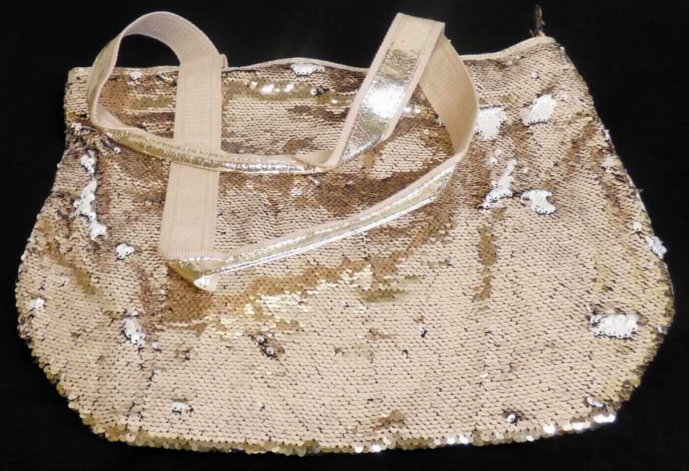 Ähnliches Behältnis (Umhängetasche), sog. Tasche Pailletten gold, Foto siehe Anlage,
- mit verschiedenen Außenseiten,
- - am Bodenteil mit einer Außenseite aus Kunststofffolien,
- - ansonsten mit einer Außenseiten aus mit Pailletten bestickten Geweben aus Spinnstoffen der Position 5810
    (Applikationsstickerei), wobei die Pailletten aus Kunststoff das Gewebe aus Spinnstoffen bedecken und den 
    mit bloßem Auge wahrnehmbaren Stoff an der Oberfläche bilden,
- mit zwei Handtragegriffen und zwei Schultertragegurten,
- mit einem ca. 2,5 cm unterhalb des oberen Rands verlaufenden Reißverschluss,
- gefüttert und mit einem Reißverschlussfach sowie zwei offenen Einsteckfächern ausgestattet,
- in den Abmessungen: ca. 42 cm (Breite) x 33 cm (Höhe) x 17 cm (Tiefe).

"Ähnliches Behältnis, anderes als in den Unterpositionen 4202 1110 bis 4202 3900 genannte, mit einer anderen
 Außenseite als in den Unterpositionen 4202 9110 bis 4202 9298 genannte, kein handgearbeitetes Behältnis für
 Musikinstrumente"