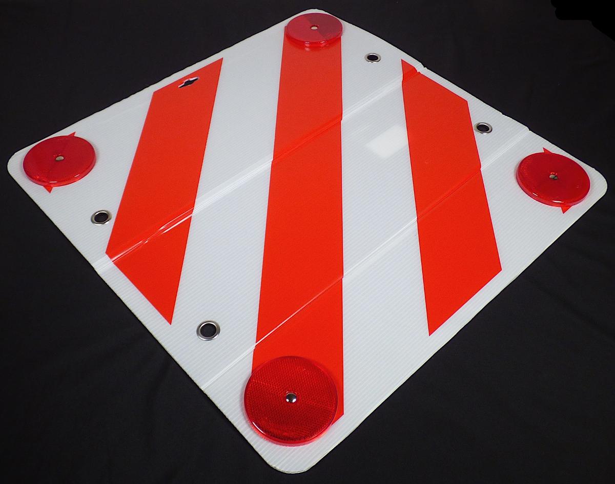 Sogenannte Warntafel (Artikelnummer 73888):

Es handelt sich um eine quadratische Tafel (Abmessungen: etwa 50 x 50 cm mit abgerundeten Ecken), bestehend aus einer PVC-Platte, die mit einer reflektierenden Folie aus Kunststoff beklebt und mit roten diagonalen Streifen bedruckt ist. An den Ecken befinden sich Reflektoren aus Kunststoff, jeweils über zwei Seiten befinden sich zwei Lochungen mit Ösen aus unedlem Metall verstärkt.

Üblicherweise wird die Ware im Bereich des Straßenverkehrs als Warntafel zur Kennzeichnung von Ladung verwendet. Dazu kann sie z. B. an Wohnwagen, Anhängern und Fahrradträgern angebracht werden. Aufgrund des universellen Einsatzortes und der fehlenden Erkennbarkeit kommt eine Einreihung in den ABS XVII als Teil oder Zubehör für ein Beförderungsmittel nicht in Betracht.

Abbildung siehe Anlage.

Derartige Waren gehören als "andere, als in den vorgenannten Unterpositionen genannte Drucke" zum TARIC-Code 4911 99 00 00.