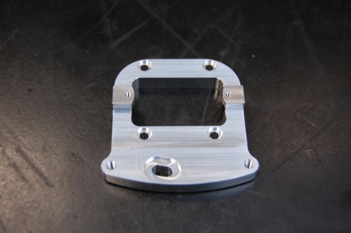 So genannte Justierplatte, in Form einer nach Maß gefertigten Halterung aus unedlen Metallen (B x T ca.: 42 x 42 mm; zur äußeren  Form siehe Abbildung in der Anlage) mit speziellen Bohrungen.
Die Ware wird in ein Spektrometer der Position 9027 eingebaut und hält dort die CCD-Zeile (beides nicht Gegenstand dieser vZTA-Entscheidung). Da die Ware im eingebauten Zustand kippbar bleibt, können mit ihrer Hilfe CCD-Zeile und Licht optimal zueinander ausgerichtet werden.

Die Ware wird als "Teil, erkennbar ausschließlich für ein Gerät der Position 9027 bestimmt" eingereiht