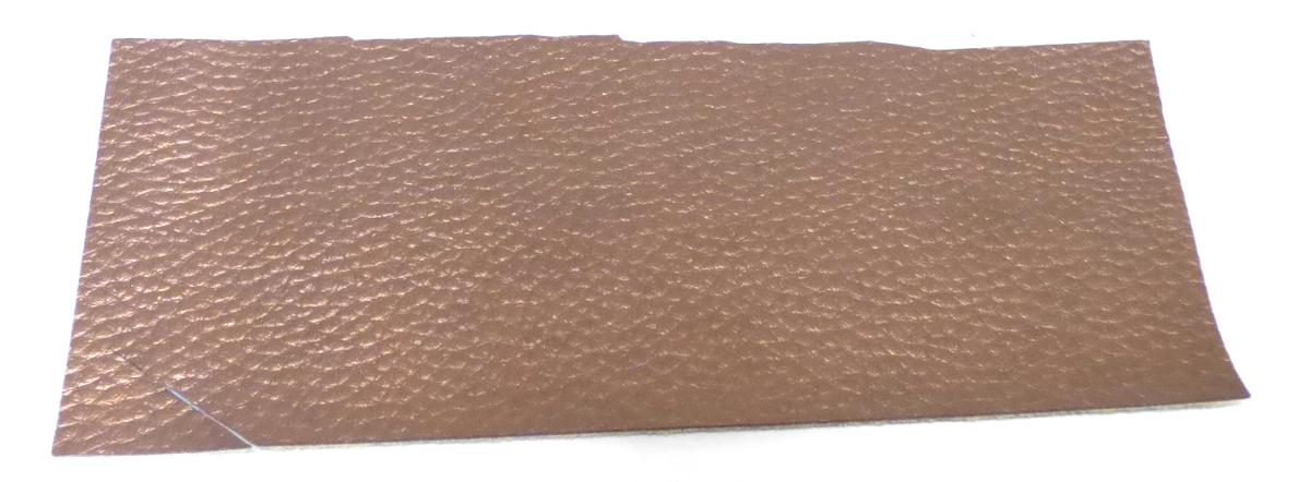 Mit Kunststoff überzogenes Gewebe, sog. Vliesstoff, Art. 276098, Foto siehe Anlage,
- rechteckig zugeschnitten; mit den Abmessungen von laut Antrag 33 cm x 182 cm,
- aus einem Gewirke (= Gewebe im Sinne des Kapitels 59, somit keine Ware der Position 5603) aus
  Spinnstoffen, das auf der Außenseite (Schauseite) mit bloßem Auge wahrnehmbar mit geprägtem, 
  metallisiertem Zellkunststoff (laut Antrag Polyurethan) überzogen ist; das Gewebe ist dicht, geraut,
  gefärbt und dicker als der Zellkunststoff und dient damit nicht nur der Verstärkung,
- von Hand bei einer Temperatur zwischen 15 und 30 °C auf einen Dorn von 7 mm Durchmesser
  aufrollbar, ohne rissig zu werden.

"Gewebe, mit Kunststoff (Polyurethan) überzogen, anderes als solche der Position 5902, anderes als in
 der Unterposition 5903 2090 20 genannte"