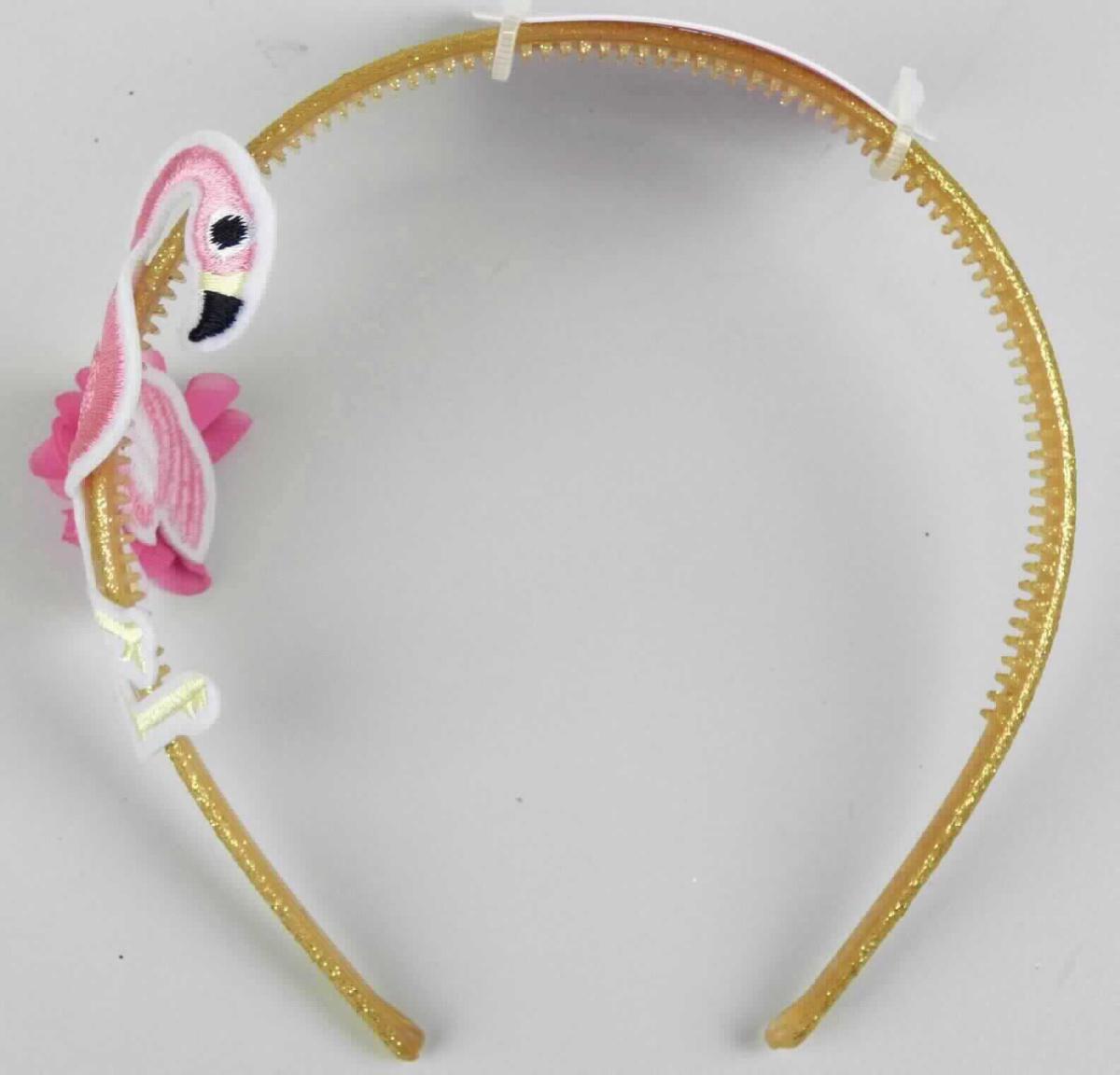 Es handelt sich um einen sog. "Haarreif" (LAN: 11613), der aus einem ca. 0,6 cm breiten, gebogenen, der Kopfform angepassten, an den Enden offenen Reif aus gelblich, transparentem Kunststoff besteht, der vollständig mit goldenem Glitter und einseitig mit einem Flamingo aus Spinnstoffen verziert ist. 

Der Kunststoff bestimmt insbesondere aufgrund seiner Bedeutung im Hinblick auf die Verwendung den Charakter der aus verschiedenen Stoffen zusammengesetzten Ware.

Die auf einer Verkaufskarte mit Aufhängeöse aufgemachte Ware wird zum Zusammen- bzw. Zurückhalten des Haares und zugleich als dekorativer Schmuck verwendet.

Das Erzeugnis ist als "haarspangenähnliche Ware aus Kunststoff" einzureihen.