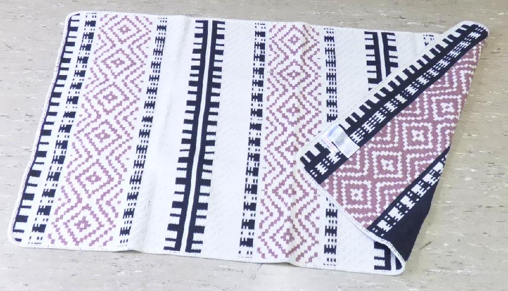 Teppich, sog. Wendeteppich, Foto siehe Anlage,
- in rechteckiger Form, 
- aus einem buntgewebten Gewebe (Jacquardgewebe) ohne Flor, aus laut Antrag 65 GHT Baumwolle
  und 35 GHT Polyester,
- an den Rändern gekettelt (somit konfektioniert),
- kein Kelim, Sumak, Karamanie oder ähnlicher Teppich,
- kein Fußbodenbelag aus Kokosfasern,
- weder getuftet noch beflockt,
- erfüllt die Bedingungen zur Einreihung als Teppich.

"Teppich, aus Spinnstoffen, gewebt, weder getuftet noch beflockt, konfektioniert, kein Kelim, Sumak,
 Karamanie und ähnlicher handgewebter Teppich, kein Fußbodenbelag aus Kokosfasern, ohne Flor,
 aus Baumwolle"