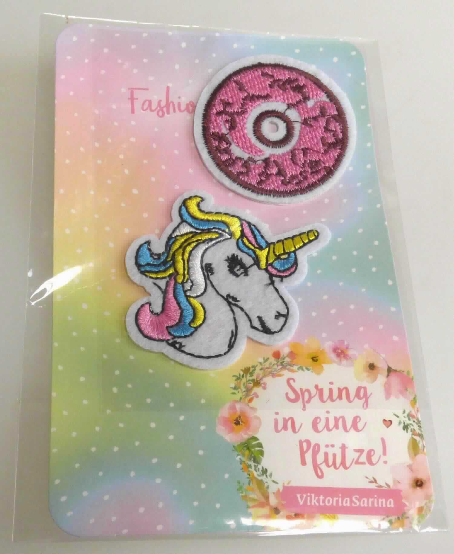 Stickereien als Motiv, sog. Textilsticker, Art. xxxx0120, Foto siehe Anlage,
- als Set mit zwei unterschiedlichen Motiven (Kopf eines Einhorns und kreisförmiges Motiv) in einem Polybeutel 
  verpackt,
- jeweils mit einem Stickgrund aus Vliesstoff aus Chemiefasern,
- mit Stickgarnen bestickt,
- keine Ätzstickerei oder Stickerei mit herausgeschnittenem Grund,
- auf der Rückseite mit einem klarsichtigen Kleber ausgestattet,
- laut Antrag mit einem Wert von mehr als 17,50 EUR je kg Eigengewicht, 
- ohne Hinweise auf Handarbeit.

"Stickereien als Motiv, andere als Ätzstickereien und Stickereien mit herausgeschnittenem Grund, aus 
 Chemiefasern, mit einem Wert von weniger als 17,50 EUR je kg Eigengewicht, nicht handgearbeitet"