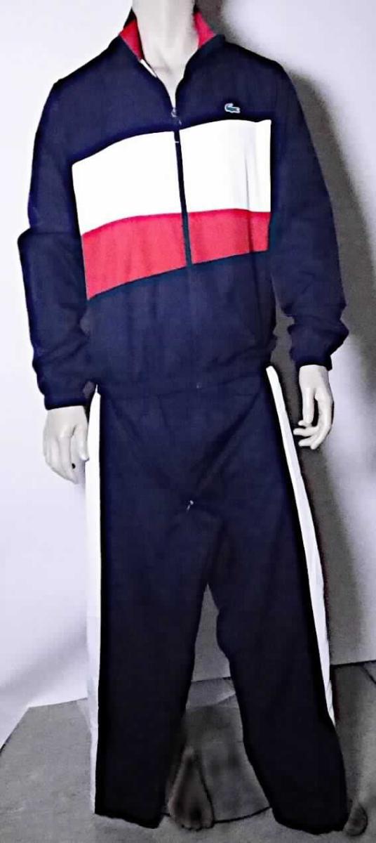 Trainingsanzug, sog. Tracksuit navy / red / white, Größe L, Foto siehe Anlage,
- bestehend aus Ober- und Unterteil, 
- in einem Polybeutel gemeinsam für den Einzelverkauf aufgemacht, 
- erkennbar dazu bestimmt, ausschließlich oder im Wesentlichen bei der Ausübung eines Sports getragen 
  zu werden, 
- aus verschiedenen, ca. 0,2 mm dicken, einfarbigen Geweben aus laut Antrag 100 % Polyester (synthetische 
  Chemiefasern), somit kein Trainingsanzug der Position 6112; mit einer aufgebrachten Verzierung (jeweils ein 
  aufgeklebtes Firmenlogo), die sich auf beiden Teilen wiederholt,
- mit einem Oberteil aus dunkelblauen, weißen und roten Geweben sowie einer langen Hose aus dunkelblauen 
  und weißen Geweben, somit nicht mit Außenseiten aus ein und demselben Flächenerzeugnis hergestellt, 
  daher getrennte Einreihung innerhalb der Position 6211,
- vollständig gefüttert,
- am Kragenrand des Oberteils mit einer kurzen Überlappung von links über rechts, somit als Männerkleidung 
  erkennbar, 
- Oberteil: 
-- über die Taille reichend (Rückenlänge: ca. 72 cm); 
-- mit einem Stehkragen,
-- vorn mit einer durchgehenden Öffnung, mit einem bis in die Kragenspitzen reichenden Reißverschluss,
-- mit langen Ärmeln; an den Ärmelenden mit verengenden, elastischen Abschlüssen,
-- mit zwei eingesetzten Taschen mit Reißverschluss unterhalb der Taille,
-- am unteren Rand mit einem verengenden, elastischen Bund.

"Trainingsanzug, aus Geweben, für Männer, aus Chemiefasern, gefüttert, nicht mit Außenseite aus ein und  
 demselben Flächenerzeugnis, Oberteil"