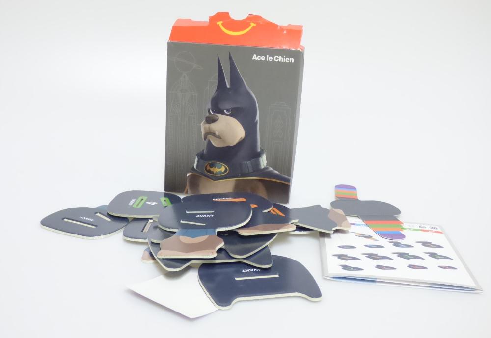 Bei dem vorliegenden und als "McDonald's - DC League of Super Pets Paper - 2022 - Ace the Hound" bezeichneten Erzeugnis handelt es sich um einen Bausatz,
- einen sitzenden Hund mit schwarzer Maske, blauem Halsband
  und schwarzem Umhang darstellend,
- aus Pappe gefertigt,
- bestehend aus 13 bedruckten Einzelteilen,
- - mit einem Gesicht mit zwei seitlich abstehenden Laschen, die
    derart bedruckt sind, dass sie die Reihenfolge der anderen Bauteile
    vorgeben,
- - die Laschen werden hinter das Gesicht geklappt,
- - die anderen Bauteile sind mit zwei farblich markierten Aussparungen
    versehen sowie entsprechend nummeriert und müssen in der richtigen
    Reihenfolge auf die Laschen gesteckt werden,
- mit einem runden Aufkleber, der auf den Rücken der zusammengesetzten
  Figur geklebt wird um diese zusammenzuhalten,
- die Einzelteile sind alleine nicht zum Spielen geeignet und sinnvoll
  aufeinander abgestimmt,
- dient der spielerischen Unterhaltung von Kindern,
- gemeinsam mit einer Bauanleitung in einem Pappkarton verpackt.

Derartige Erzeugnisse sind zolltarifrechtlich als "anderes als in den Unterpositionen (KN) 9503 0010 bis 9503 0030 erfasstes Spielzeug, Bausatz, nicht aus Kunststoff oder handgearbeitet aus Holz" einzureihen.