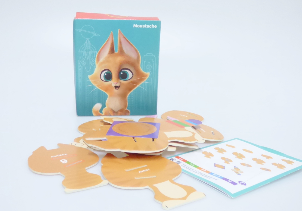 Bei dem vorliegenden und als "McDonald's - DC League of Super Pets Paper - 2022 - Whiskers" bezeichneten Erzeugnis handelt es sich um einen Bausatz,
- eine sitzende Katze mit spitzen Ohren und getigertem Fell darstellend,
- aus Pappe gefertigt,
- bestehend aus 13 bedruckten Einzelteilen,
- - mit einem Gesicht mit zwei seitlich abstehenden Laschen, die
    derart bedruckt sind, dass sie die Reihenfolge der anderen Bauteile
    vorgeben,
- - die Laschen werden hinter das Gesicht geklappt,
- - die anderen Bauteile sind mit zwei farblich markierten Aussparungen
    versehen sowie entsprechend nummeriert und müssen in der richtigen
    Reihenfolge auf die Laschen gesteckt werden,
- mit einem runden Aufkleber, der auf den Rücken der zusammengesetzten
  Figur geklebt wird um diese zusammenzuhalten,
- die Einzelteile sind alleine nicht zum Spielen geeignet und sinnvoll
  aufeinander abgestimmt,
- dient der spielerischen Unterhaltung von Kindern,
- gemeinsam mit einer Bauanleitung in einem Pappkarton verpackt.

Derartige Erzeugnisse sind zolltarifrechtlich als "anderes als in den Unterpositionen (KN) 9503 0010 bis 9503 0030 erfasstes Spielzeug, Bausatz, nicht aus Kunststoff oder handgearbeitet aus Holz" einzureihen.