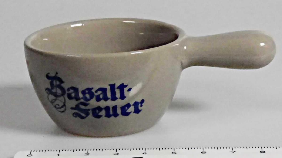 Keramisches Geschirr, sog. Schnapspfännchen, Artikel 1005728, Foto siehe Anlage,
- graues, glasiertes, kleines Pfännchen mit der Aufschrift "Basaltfeuer" und mit einem Stielgriff, 
- in den Abmessungen (ohne Stiel): 3,4 cm (Höhe) x 5,8 cm (Durchmesser),
- keramisches Erzeugnis, nach der Formgebung gebrannt, tonmineralhaltiges Material enthaltend, 
- nach dem Ergebnis der wissenschaftlichen Untersuchung handelt es sich bei der Keramik weder 
  um Porzellan noch um gewöhnlichen Ton, Steinzeug, Steingut oder feine Erden; das Schnapspfännchen
  ist damit als Geschirr aus "anderer Keramik" anzusehen,
- dient als Trinkgefäß z. B. für Kräuterliköre.

"Keramisches Geschirr (Schnapspfännchen), aus anderer Keramik als Porzellan, gewöhnlicher Ton,
Steinzeug, Steingut oder feine Erden"