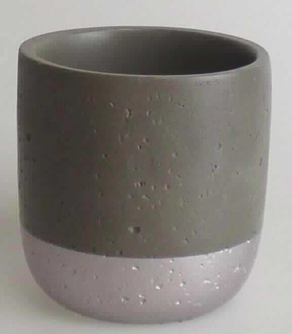 Angaben:
Zahnputzbecher aus Beton/Zement.

Warenbeschaffenheit:
Grauer Becher (Höhe ca. 90 mm, Durchmesser ca. 85 mm), das untere Drittel mauvefarben bemalt. Der Artikel besteht aus einem grauen, heterogenen Material mit Einschlüssen.

Befund:
Waren aus Zement, Beton oder Kunststein