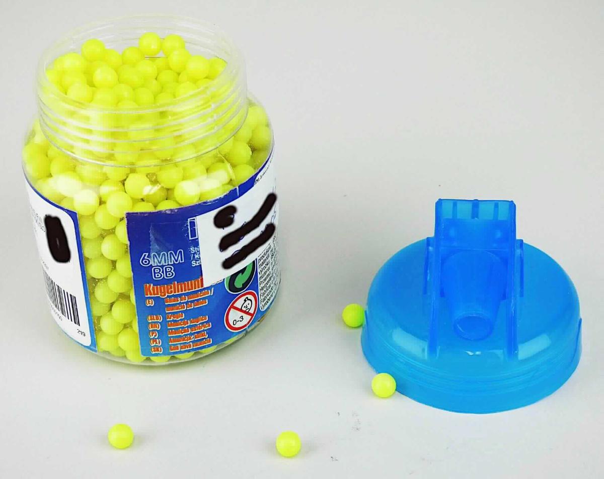 Bei dem Erzeugnis handelt es sich um massive kleine Kugeln aus Kunststoff mit einem Durchmesser von jeweils etwa 6 mm. Diese sind zu etwa 1000 Stück in einer Dose mit Tülle aus Kunststoff lose abgefüllt. Die Dose ist mit einem mit Produktinformationen und Warnhinweisen bedruckten Etikett beklebt. 
Derartige Kugeln werden gleichermaßen als Munition (Geschosse) für Feder- oder Druckluftwaffen der Pos. 9304 und als Zubehör für Spielzeugwaffen der Pos. 9503 verwendet.

Abbildung siehe Anlage.

Derartige Waren gehören als "Geschosse, andere als die der Unterpositionen 9306 21 00 bis 9306 90 10" zur Codenummer 9606 90 90 00 0 des Zolltarifs.