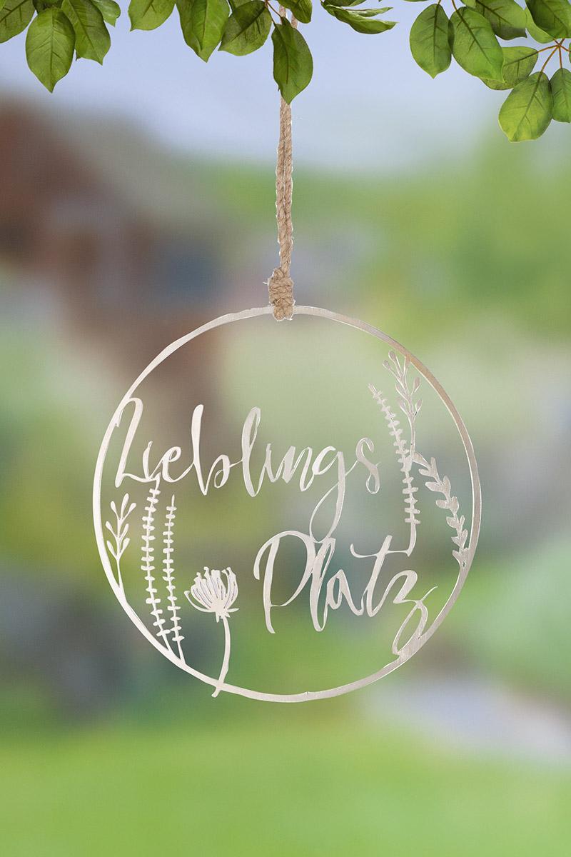 Es handelt sich um ein kreisrundes, flaches Erzeugnis aus unedlem Metall (Aluminium) mit Durchbrechungen in unterschiedlichen Formen und Größen, die einen Ring im Inneren mit einem Schriftzug "Lieblingsplatz" sowie Blumenmotiven bilden. An der Oberseite des Erzeugnisses ist eine Kordel aus nicht metallischem Stoff zum Aufhängen z. B. an der Wand oder Tür befestigt.
- Antragstellerangaben -

Eine Einreihung als Ziergegenstand der Position 8306 kommt aufgrund des eigenen Gebrauchswertes des Erzeugnisses als Schild nicht in Betracht.

Das unedle Metall ist im Hinblick auf den Umfang und die Bedeutung für die Verwendung charakterbestimmend.

Abbildung siehe Anlage.

Derartige Erzeugnisse gehören als "Hinweisschilder und ähnliche Schilder, aus unedlen Metallen" zum TARIC-Code 8310 0000 00.