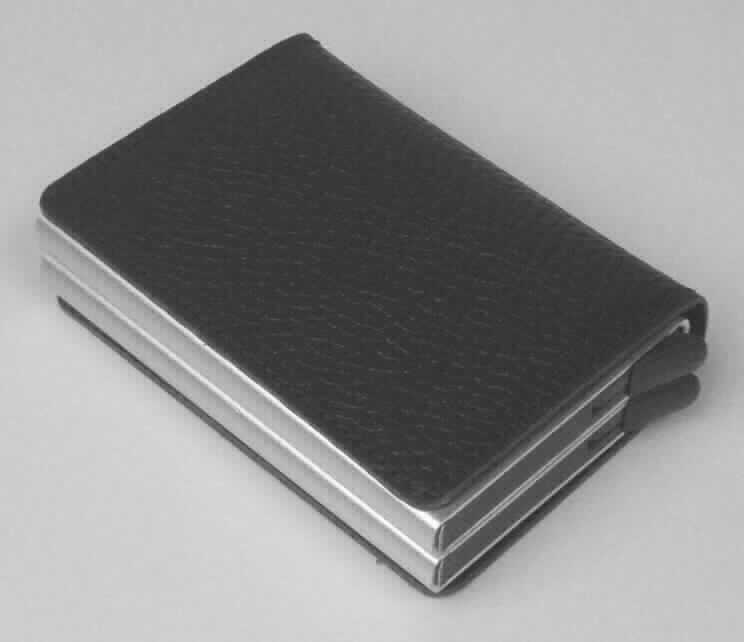 Ähnliches Behältnis (Kreditkartenetui), Taschen- und Handtaschenartikel, sog. Lederhülle mit Aluminium-Kredit-
kartenhülle, Foto siehe Anlage,
- mit einer als Umschlag gearbeiteten, flächenmäßig überwiegenden (charakterbestimmenden) Außenseite aus 
  laut Antrag Leder (sog. Lederhülle),
- ansonsten mit einem Korpus aus unedlem Metall (laut Antrag Aluminium) und aus formgepresstem Kunststoff,
- auf der Innenseite des Umschlags mit zwei offenen Einsteckfächern,
- mit einem zweigeteilten, oben offenen, passgenau zum Einstecken von Kreditkarten gearbeiteten Korpus; auf 
  der Unterseite mit einem Ausgabemechanismus zum Auswurf der Kreditkarten,
- in den Abmessungen: ca. 9,5 cm (Höhe) x 7 cm (Breite) x 2,5 cm (Tiefe),
- ohne Hinweise auf Handarbeit. 

"Ähnliches Behältnis (Kreditkartenetui), Taschen- oder Handtaschenartikel, mit Außenseite aus Leder, nicht
 handgearbeitet"