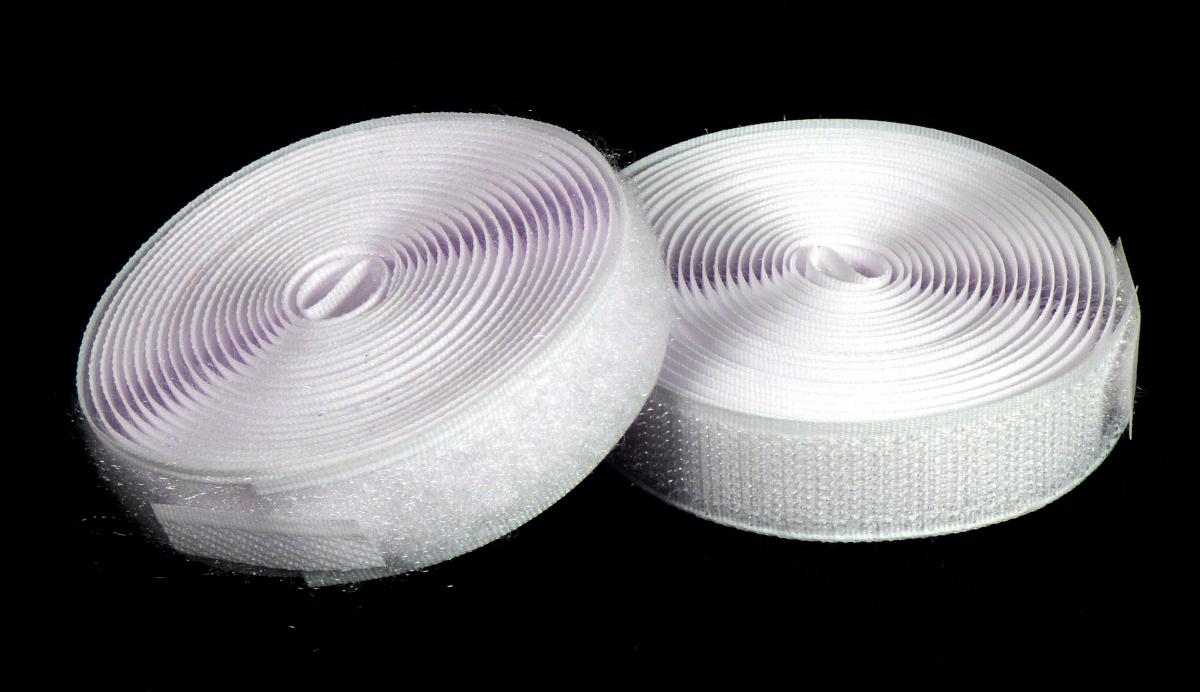 Klettbänder, sog. Klettverschlussband, Foto siehe Anlage,
- als zweiteiliges Sortiment in einer bedruckten Pappschachtel verpackt,
- als Meterware, jeweils mit einer Breite von ca. 2 cm und einer Länge von laut Antrag 3 m, 
- bestehend aus einem Hakenband (Samtgewebe mit Flor) und einem Flauschband 
  (Schlingengewebe mit Flor), beide aus synthetischen Chemiefasern (laut Antrag Polyester), 
- jeweils:
-- an den beiden Längsseiten augenscheinlich mit unechten Webkanten, 
-- an den Schmalseiten lediglich geschnitten (nicht konfektioniert).

"Bänder, keine Waren der Position 5807, aus Samt bzw. aus Schlingengewebe nach Art der Frottier- 
 gewebe, aus Chemiefasern"