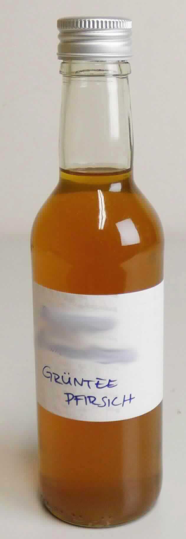 Grüntee-Konzentrat, aromatisiert, zum Herstellen von Teegetränken.

Beschaffenheit des vorgelegten, nicht original verpackten Warenmusters:
Gelbstichige, braune, leicht trübe Flüssigkeit; Geruch fruchtig, stark aromatisiert nach Pfirsich; Geschmack bitter nach grünem Tee, leicht adstringierend, süßlich, etwas säuerlich, leicht fruchtige Note; anleitungsgemäße Zubereitung (1 Teil Konzentrat, 4 Teile Wasser) ergibt ein handelsübliches aromatisiertes Grünteegetränk.

Milchfett, Milchprotein (gemäß Antragsangaben): nicht enthalten
Saccharose, einschließlich Invertzucker als Saccharose berechnet (HPLC): weniger als 5 GHT  
Isoglucose (HPLC): nicht nachweisbar
Stärke oder Glucose (HPLC nach enzymatischem Aufschluss): nicht nachweisbar

Zubereitung auf der Grundlage von Auszügen aus Tee, kein Milchfett, Milchprotein und keine Isoglucose, Stärke oder Glucose enthaltend, weniger als 5 GHT Saccharose enthaltend.