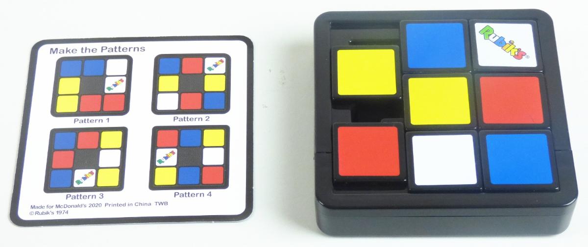 Gedulds- und Geschicklichkeitsspiel, sog. "Mc Donald´s - Rubik´s Cube - 2020, Motiv "Slide"
- mit den Abmessungen von insgesamt ca. 7,8 cm (B) x 7,8 cm (T) x 1,6 cm (H),
- in einem Gehäuse befindet sich ein quadratischer Rahmen, in dem sich acht verschiebbare Plättchen in verschiedenen Farben befinden; durch das Fehlen eines Plättchens können die Teile verschoben und so in der vorgesehenen Reihenfolge musterartig angeordnet werden,
- dient der spielerischen Unterhaltung von Kindern und Erwachsenen,
- mit einer Spielanleitung gemeinsam in einem Polyethylenbeutel verpackt.

Zolltarifrechtlich handelt es sich um ein "Puzzle, nicht aus Holz".