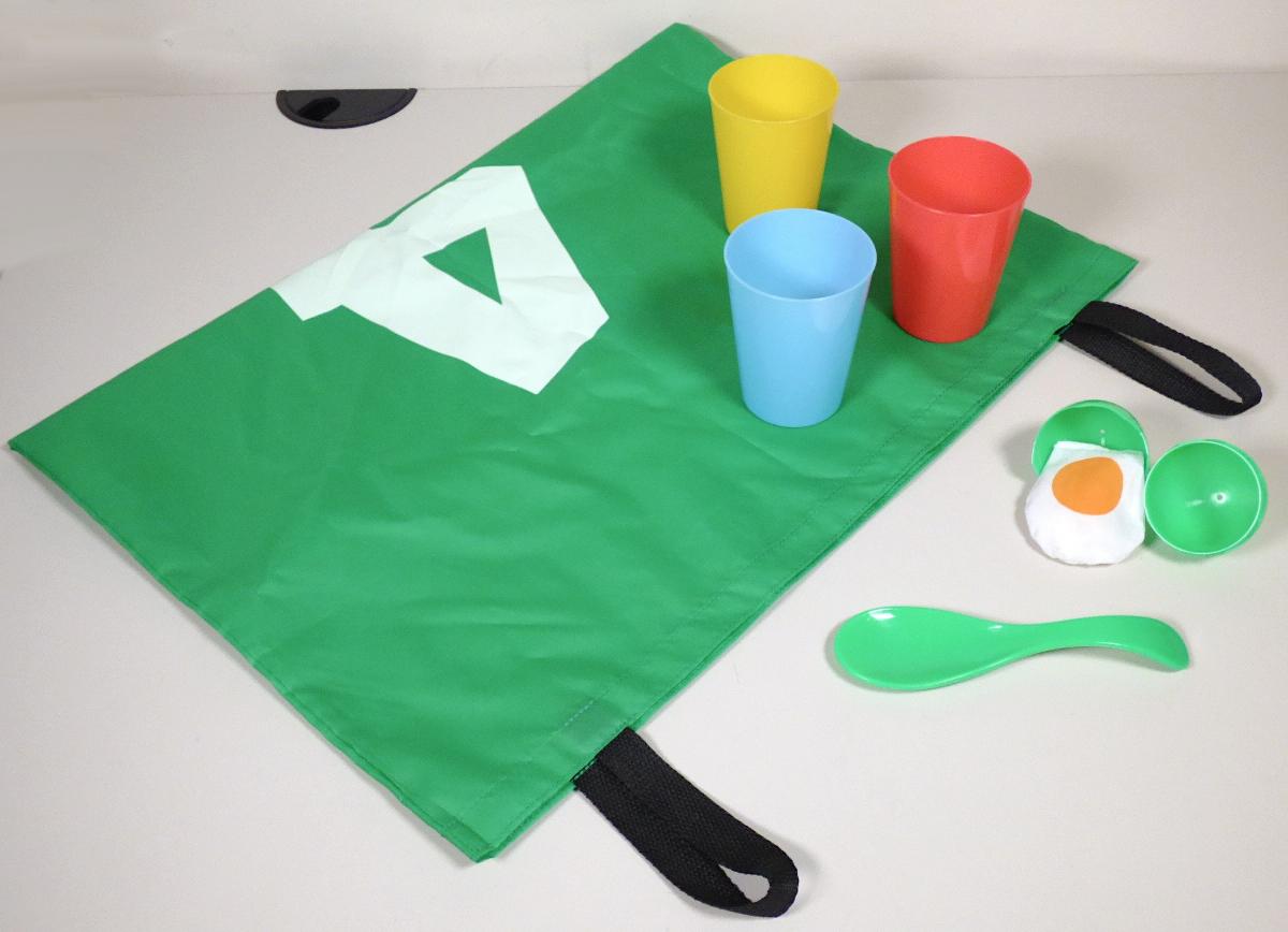 Nach den Angaben der Antragstellerin und dem nachträglich erhaltenen Warenmuster handelt es sich bei der als "Partyspiele für Kinder" bezeichneten Ware um eine Verkaufseinheit, bestehend aus 
- einem als "Eierlaufen" bezeichneten Set,
- 4 Hüpfsäcken aus Polyester mit Haltegriffen für sog. "Sackhüpfen"
- einem Set für das sog. "Dosenwerfen", bestehend aus 10 bunten Bechern zum Stapeln 
- Start- und Ziellinie aus Gewebebändern
- und vier sog. Erdnägeln aus Kunststoffen
- alles gemeinsam in einem bunt bedruckten Pappkarton verpackt. 

Eine gemeinsame Einreihung der Bestandteile der Verkaufseinheit als Warenzusammenstellung im Sinne der AV 3 b) kommt nicht in Betracht, da die verschiedenen "Spiele" keinen gemeinsamen Bedarf befriedigen oder zur Ausübung einer Tätigkeit zusammengestellt sind, sondern stattdessen alternativ verwendet werden. Daher erfolgt die Einreihung nach jeweils eigener Beschaffenheit in verschiedenen Positionen (vgl. vZTA DEBTI-5727/23-2 bis -5). 

Das Eierlaufset besteht aus
- vier verschiedenfarbigen, stilisierten Löffeln aus Kunststoff
  (ca.16,5 cm breit, mit einer 4,5 cm breiten Auflagefläche und gewölbtem Griff)
- vier verschiedenfarbigen (in den gleichen Farben wie die Löffel), ca. 8,5 cm großen,
  eiförmigen, zweiteiligen Hüllen aus Kunststoff, die zur Aufnahme der im Set enthaltenen "Eier"
  bestimmt sind
- vier annähernd oval zugeschnittenen (ca. 7 cm lang und max. 6 cm breiten) und scheibenförmigen,
  stilisierten Eiern aus konfektionierten Spinnstoffgeweben (mit körnigem Material gefüllt),
  die in der Optik ein Spiegelei nachahmen. 

Mit diesem Set können bis zu vier Personen, jeweils mit einem auf dem Löffel platzierten, mit einem Säckchen befüllten Ei, um die Wette laufen. Wessen Ei auf den Boden fällt und kaputt geht, ist entweder ausgeschieden oder muss von vorne beginnen. Gewonnen hat der / die Spielende, der / die zuerst mit einem Ei auf dem Löffel das vereinbarte Ziel erreicht. 

Waren dieser Art werden zolltarifrechtlich als "andere als in den Unterpositionen 9504 2000 bis
9504 9010 (KN) genannte Gesellschaftsspiele" eingereiht.