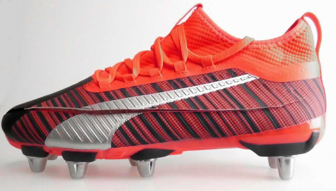 Rugbyschuhe (laut Antrag: "PUMA ONE Rugby 1 H8", Art. 105627, Größe 8 UK, Foto siehe Anlage)
- mit Laufsohlen aus (laut Antrag) Kautschuk, mit jeweils 8 abstehenden, stollenähnlichen Vorrichtungen versehen,
- mit Oberteil (geschlossenes Blatt) aus Kunststoff (Spinnstoff mit einer mit bloßem Auge wahrnehmbaren
  Außenschicht aus Kunststoff, den größten Teil der Außenfläche bildend, somit keine Ware der Position 6404),
  Leder und Spinnstoff,
- auf das Oberteil sind Stücke aus Kunststoff und Spinnstoff als Verstärkungsteile aufgesetzt,
- über dem Spann mit einer Schnürvorrichtung.

"Schuhe (Sportschuhe), andere als in der Position 6401 genannte, mit Laufsohlen aus Kautschuk und Oberteil aus 
 Kunststoff, andere als in den Unterpositionen 6402 1210 und 6402 1290 genannte"