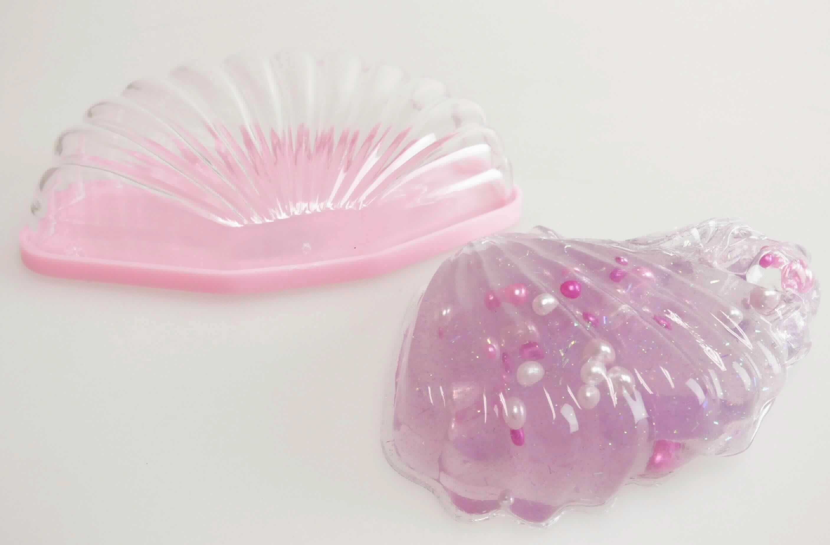 Angaben: 
Kunststoffmuschel mit Glibberinhalt; zur Unterhaltung (z.B. kneten, formen) von Kindern.  

Warenbeschreibung: 
Fliederfarbene, mit Glitterpartikel und Perlen durchsetzte, knetbare Masse, verpackt in einer Kunststoffverpackung in Form einer stilisierten Muschel.

Befund: 
Modelliermasse, auch zur Unterhaltung für Kinder.