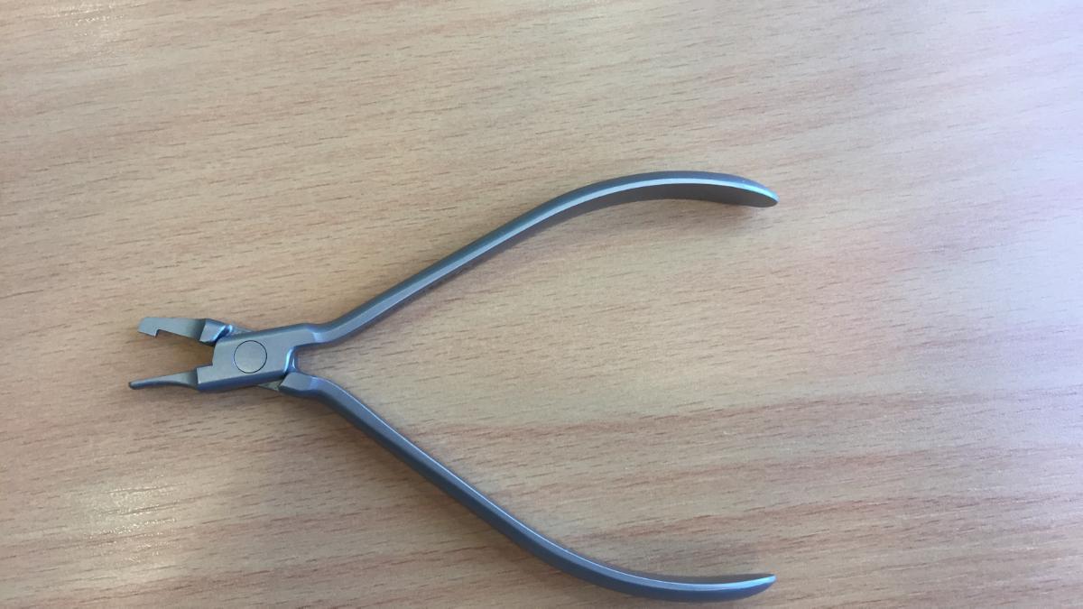 Kieferorthopädische Zange, in Form eines spezifisch geformten, zangenähnlichen Instruments mit gebogenen Handgriffen, augenscheinlich aus blendfreiem unedlem Metall, mit einer leicht gebogenen, hakenähnlichen Arbeitsspitze auf einer Seite und mit einer konisch verlaufenden, flachen Arbeitsspitze auf der andren Seite.
Äußere Form: siehe Abbildung in der Anlage.
Die Ware wird als kieferorthopädische Zange für kieferorthopädische Drähte, Brackets und Aligner verwendet.

Die Ware wird als "zahnärztliches Instrument, nicht von den Unterpositionen (KN) 9018 1100 bis 9018 4910 erfasst" eingereiht..