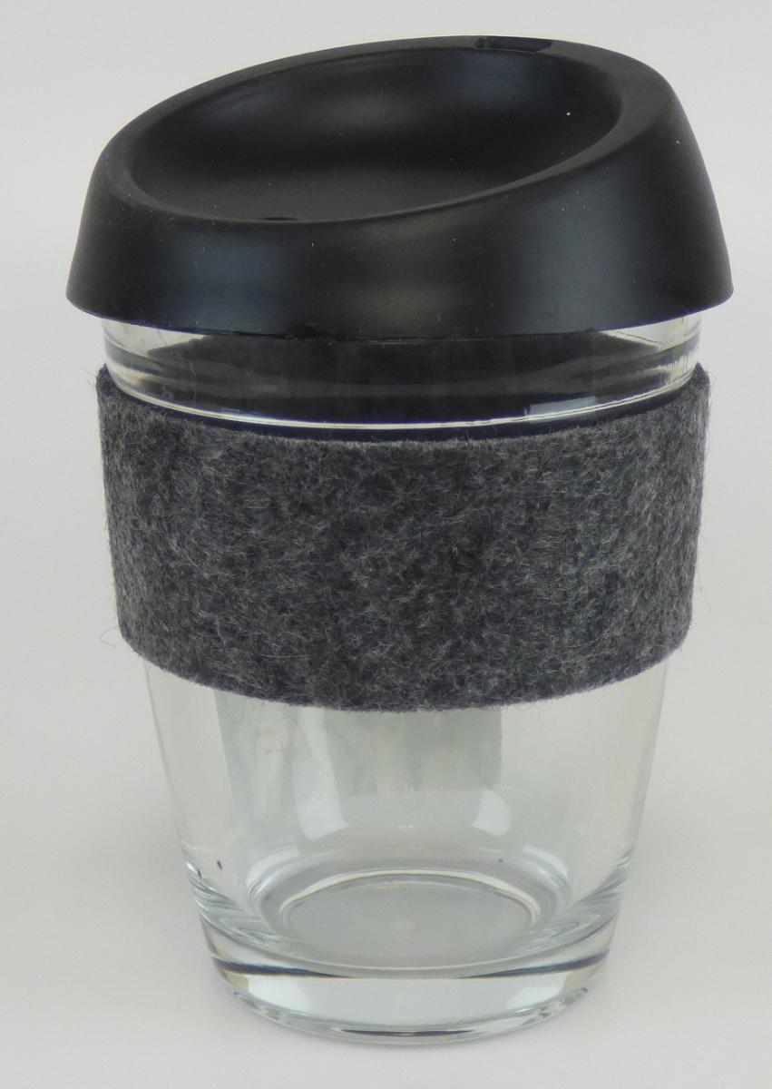 Trinkglas, sog. Glaskaffeebecher, Foto siehe Anlage,
- aus verschiedenen Stoffen zusammengesetzte Ware, bestehend aus:
- - einem Trinkglas ohne Stiel:
- - - aus klarsichtigem Glas (laut Antrag mechanisch gefertigtes Borosilikatglas),
- - - in den Abmessungen: ca. 8,5 cm (Durchmesser) x 11 cm (Höhe),
- - einem abnehmbaren Deckel aus Kunststoff (laut Antrag Silikon),
- - - mit einer kleinen, schlitzartigen Öffnung als Trinkmöglichkeit mit geschlossenem Deckel
      und einer weiteren, kleinen Öffnung (z. B. für einen Trinkhalm),
- - einer Manschette aus Spinnstoff (laut Antrag Filz aus Polyester),
- das Glas bestimmt nach dem Umfang und aufgrund seiner Bedeutung in Bezug auf die Verwendung
  den wesentlichen Charakter der zusammengesetzten Ware.

"Glasware zur Verwendung bei Tisch, Trinkglas ohne Stiel, nicht aus Glaskeramik, Bleikristall oder
 vorgespanntem Glas, mechanisch gefertigt, weder geschliffen noch anders bearbeitet"