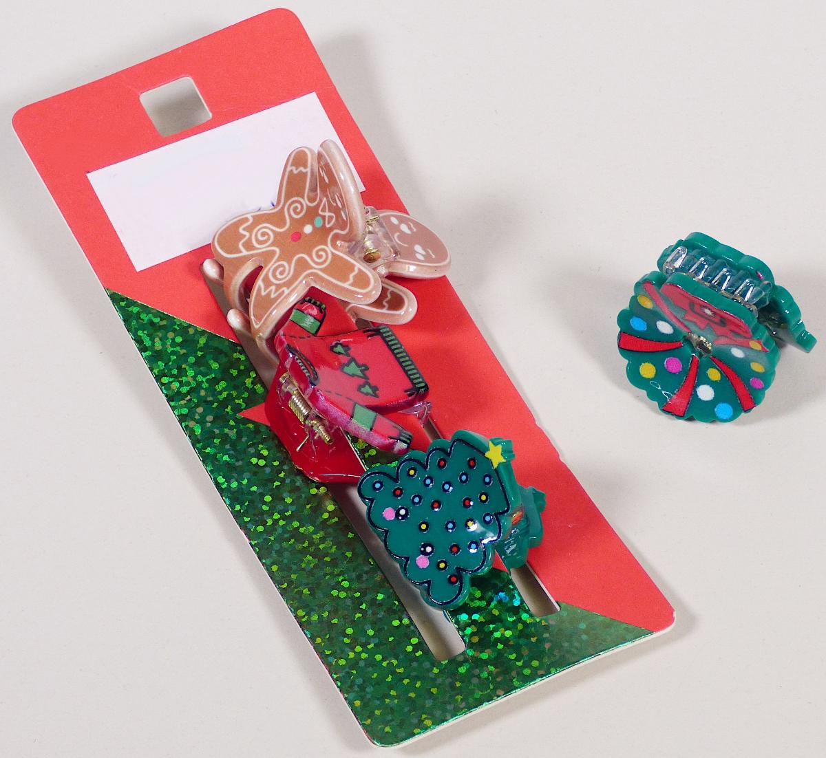 Bei dem sog. "X-Mas Haircrab Set, Art.Nr. 396855" handelt es sich um vier ca. 2,5 - 3 cm breite Haarspangen, bestehend aus zwei zueinander gebogenen Kämmen, deren Zinken ineinander greifen und die mittels einer Feder zusammengehalten werden.

Die Haarspangen bestehen aus farbigem Kunststoff (charakterbestimmendes Material insbesondere aufgrund des Umfangs), lediglich die Feder und der Stift bestehen aus unedlen Metallen.

Die Ware dient dem Zusammenhalten der Haare und kann gleichzeitig als Haarschmuck verwendet werden. Die Spangen sind in verschiedenen Motiven und auf einer Verkaufskarte mit Aufhängeöse für den Einzelverkauf aufgemacht.

Die Erzeugnisse sind als "Haarspangen, aus Kunststoff" einzureihen.
