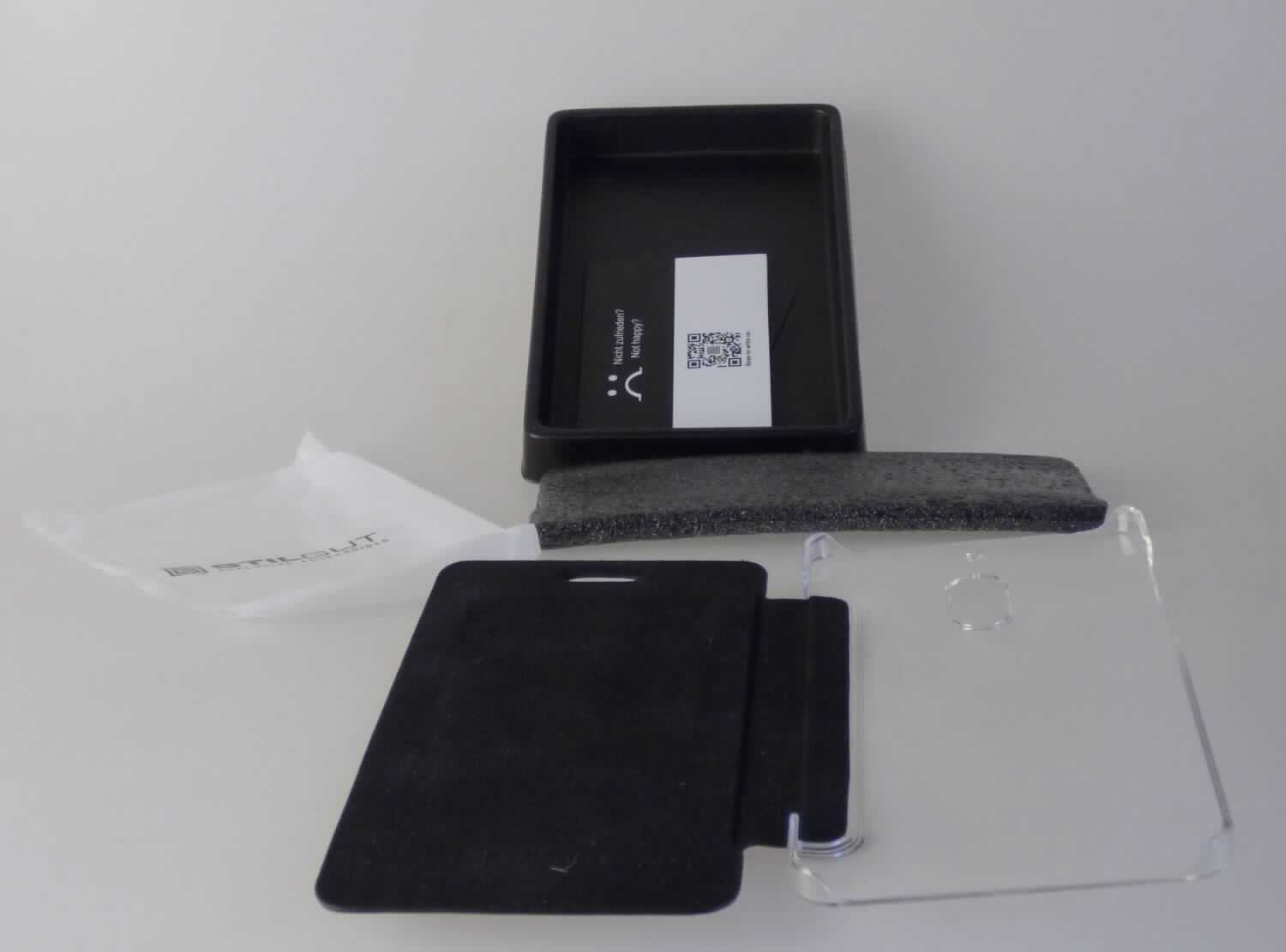 Etuiähnliches Behältnis, Taschen- oder Handtaschenartikel, sog. STILGUT - NOKIA 6 BOOK TYPE NFC / 
RFID BLOCKING HÜLLE, Artikelnummer FNSKU: B0785W994K, Foto siehe Anlage,
- verpackt in einer handelsüblichen Schachtel,
- mit einer Außenseite aus flächenmäßig überwiegendem (charakterbestimmendem) Leder,
- - im Bereich der Überschlagklappe, dem überwiegenden Teil einer Schmalseite sowie einem schmalen Streifen
    auf der Rückseite mit einer Außenseite aus Leder, das mit einer mit dem bloßen Auge nicht wahrnehmbaren 
    Lage aus Kunststoff (laut Untersuchungsergebnis mit einer Dicke von ca. 0,02 mm) versehen ist,
- - im überwiegenden Teil der Rückseite und Teilen der beiden Schmalseiten mit einer Außenseite aus formge-
    presstem, klarsichtigem Kunststoff (Einsteckschale für das Mobiltelefon),
- seitlich aufklappbar; ohne Verschluss,
- mit Aussparungen für die Kameralinse und zur Bedienung des Mobiltelefons versehen,
- in den Abmessungen: ca. 15,5 cm (Höhe) x 8 cm (Breite) x 1 cm (Tiefe), 
- dient dem Transport und der Aufbewahrung eines Mobiltelefons in einer Tasche oder Handtasche, 
- ohne Hinweise auf Handarbeit.

"Etuiähnliches Behältnis, Taschen- oder Handtaschenartikel, mit Außenseite aus Leder, nicht handgearbeitet"