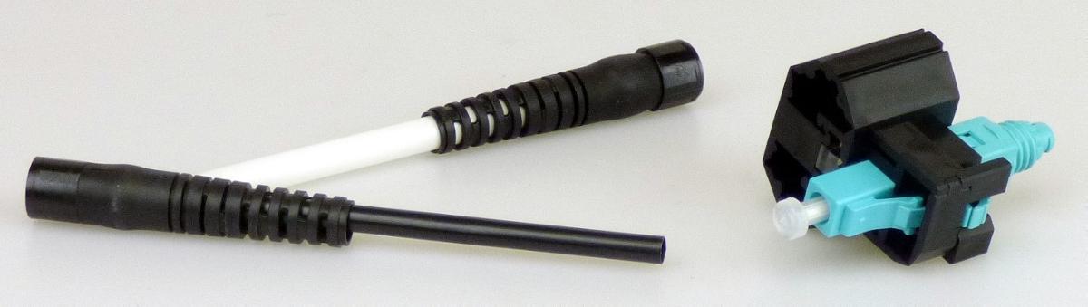 Sog. Multimode Schnell Stecker, in Form einer zusammengesetzten Ware,
- aus einem optischen Stecker (charakterbestimmend aufgrund der Bedeutung für die Verwendung) bestehend aus einer Keramikferrule in einem Kunststoffgehäuse mit Staubschutzkappe und Knickschutztülle, eingeschoben in eine Kunststoffklammer,
- zum Verbinden und mechanischen Ausrichten von optischen Fasern, Bündeln aus optischen Fasern oder optischen Kabeln,
- noch nicht zusammengesetzt,
- mit nicht charakterbestimmendem Beipack (einer weiteren Knickschutztülle und Anleitungen) in Polybeuteln und einem Karton verpackt.

Die Ware ist als "Verbinder für optische Fasern, Bündel aus optischen Fasern oder optische Kabel, nicht für bestimmte Luftfahrzeuge" einzureihen.

Anlage: 1 Abbildung
