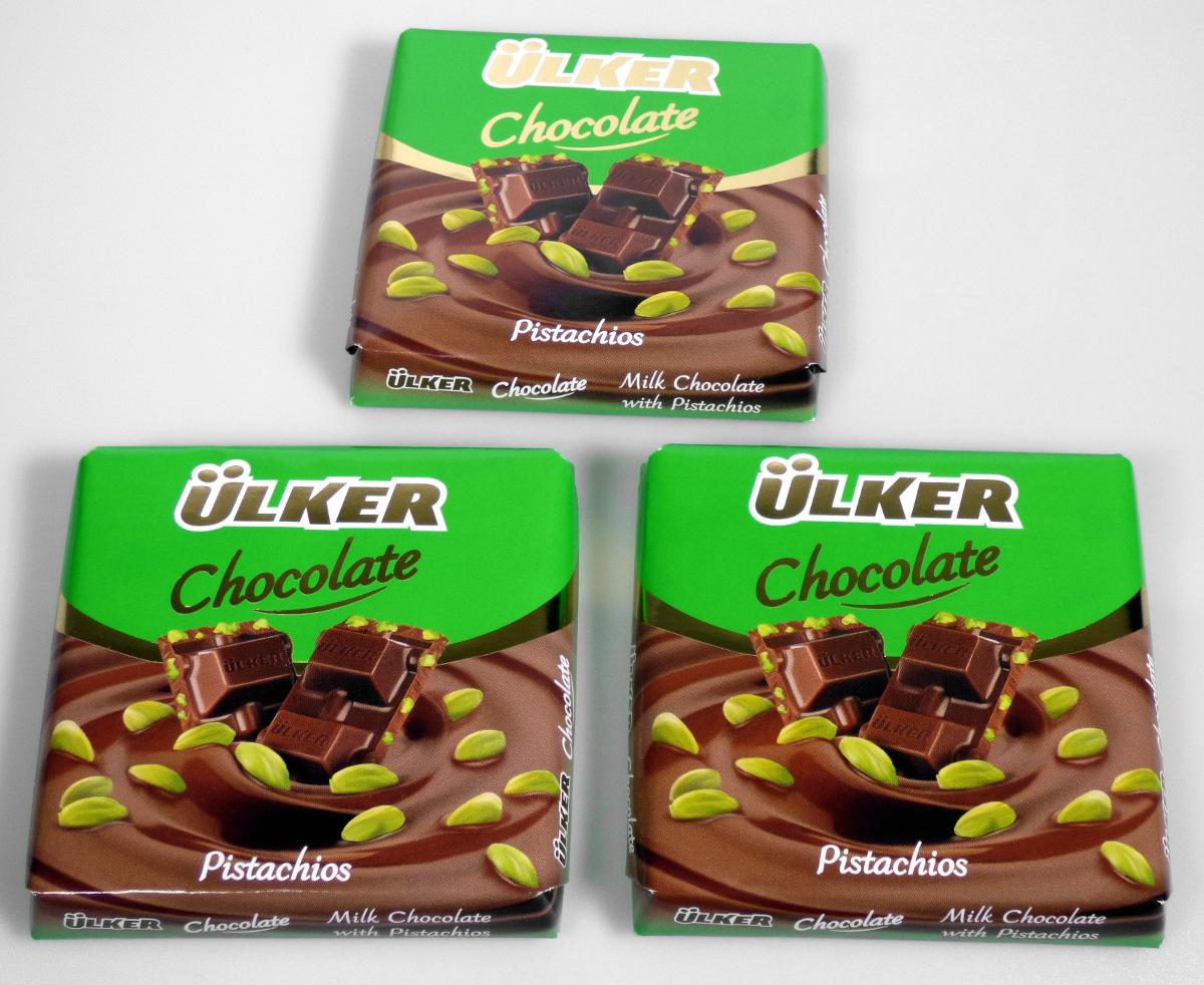 Angaben des Antragstellers:
Milk Chocolate with Pistachios, Ingredients: sugar 34,3 %, Milk Powder 21,5 %, Cocoa butter 16,3 %, Emulsifier (soya lecithin) 0,4 %, Cocoa mass 10,3 %, Flavour 0,2 %, Pistachios 17 %.
Verpackungseinheit: 70 g-Packungen.

Feststellungen an einem Warenmuster:
Verpackung: Bunt bedrucktes Papier und Metallfolie, Kennzeichnung (Auszug): "ÜLKER, Chocolate, Pistachios, Milchschokolade mit Pistazien, Zutaten: Zucker, Vollmilchpulver, Pistazien (18 %), Kakaobutter, Kakaomasse, Sojalecithin, Speisesalz, Aroma, 70 g".
Warenbeschaffenheit: Tafel aus Milchschokolade mit Bruchkerben, durchzogen von ganzen Pistazien (Abmessungen: circa 8,5 x 8,5 x 1,2 cm); Geruch: nach Schokolade; Geschmack: süß, nach Schokolade und Pistazien.

Befund:
Die Einreihung erfolgt auf der Grundlage der Antragsangaben. Danach und nach dem Untersuchungsergebnis liegt eine nicht gefüllte Tafel aus Vollmilchschokolade, die Pistazien enthält, vor.

Schokolade und andere kakaohaltige Lebensmittelzubereitungen: andere, in Form von Tafeln, Stangen oder Riegeln: nicht gefüllt: mit Zusatz von Getreide, Früchten oder Nüssen.
