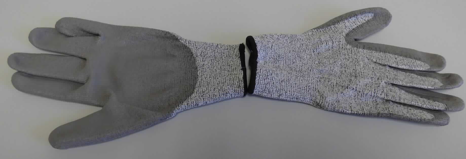 Fingerhandschuhe, sog. Arbeitshandschuhe Schnittschutz, in Erwachsenengröße, Foto siehe Anlage,
- als Fünffingerhandschuhe gearbeitet,
- aus buntgewirkten Gewirken aus laut Antrag 100 % synthetischen Chemiefasern,
- mit einer elastischen Stulpe aus buntgewirkten Gewirken aus laut Antrag 94 % synthetischen Chemiefasern und 
  6 % Elastodien (Kautschukfäden),
- nachträglich mit Ausnahme des größten Teils der Stulpe, des Handrückens sowie Teilen der Fingeraußenseiten 
  einseitig (Außenseite) im Tauchverfahren mit Kunststoff (laut Antrag: Polyurethan, keine Zellstruktur erkennbar) 
  überzogen,
- am unteren Rand mit einer kontrastfarbenen Überwendlichnaht gesäumt.

"Fingerhandschuhe, aus Gewirken, mit Kunststoff überzogen"