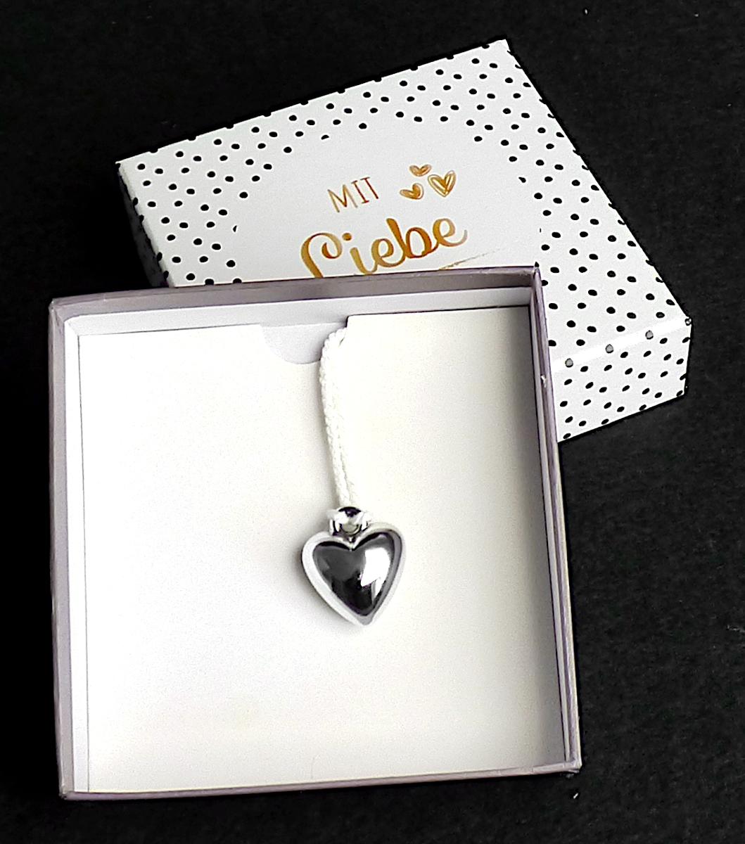 Sogenannte Geschenkbox Mini mit einem Herz (Artikelnummer: 377960): 

Es handelt sich um eine aus verschiedenen Bestandteilen zusammengesetzte Ware, bestehend aus
- einer Stülpdeckelschachtel aus Papier/Pappe mit äußerem Überzug aus einer bedruckten Kunststofffolie (Acrylnitril-Butadien-Styrol). Die Schachtel weist die Maße von rd. 11 x 11 x 3 cm (L x B x H) auf.  
- einem herzförmigen Anhänger aus Kunststoff an einer kurzen Kordel aus Spinnstoff (mittels Kordel aus Spinnstoff in die Schachtel geklebt).

Abbildung siehe Anlage.
Die Stülpdeckelschachtel ist keine Verpackung im Sinne der AV 5 b).
Im Hinblick auf den Umfang, die Bedeutung für die Verwendung  und das Gewicht ist die Stülpdeckelschachtel charakterbestimmend im Sinne der AV 3 b).

Derartige Erzeugnisse gehören als "andere Verpackungsmittel aus Papier oder Pappe" zur Codenummer 4819 5000 00 0.