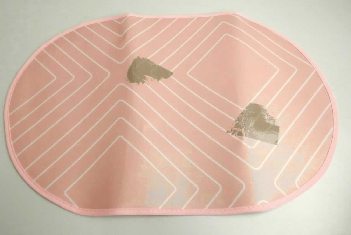 Platzmatte, sog. Tischdecke, Platzset NAN7173629, Foto siehe Anlage, 
- annähend in ovaler Form, mit abgeflachten Längsseiten, mit den max. Abmessungen (L x B): ca. 45 cm x 30 cm,
- aus einem punktuell thermisch verfestigten und geprägten Vliesstoff aus laut Antrag 100 % Polypropylen 
  (synthetische Chemiefasern), der auf der Außenseite mit einer Folie aus Kunststoff (laut Antrag: PEVA