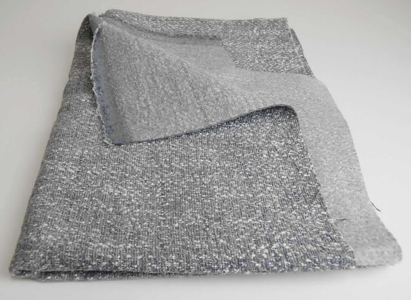 Gewebe, sog. Möbelbezugsstoff, Foto siehe Anlage, 
- als Meterware, mit einer Breite von mehr als 30 cm, 
- laut Untersuchungsergebnis: 
- - aus einem buntgewebten Gewebe in Musterbindung aus nicht hochfesten Garnen, 
- - - mit Kett- und Schussgarnen aus synthetischen Filamenten (Polyester), 
- - - mit dicken Kett- und Schussgarnen (Effektzwirn), bestehend aus zwei dünnen Garnen aus synthetischen 
      Filamenten (Polyester) und einem dicken Garn aus synthetischen Spinnfasern (Polyester), 
- - - mit dicken Schussgarnen (Chenillegarnen) aus synthetischen Spinnfasern (Polyester), 
- - mit einem Gesamtanteil an: 
- - - synthetischen Spinnfasern von ca. 60 - 65 GHT, somit keine Ware der Position 5407, 
- - - synthetischen Filamenten von ca. 35 - 40 GHT,  
- - u. a. aufgrund der fehlenden samtartigen Oberfläche kein Chenillegewebe der Position 5801.
- - auf der Rückseite geraut und dünn, mit dem bloßen Auge nicht wahrnehmbar mit Kunststoff bestrichen.

"Gewebe aus synthetischen Spinnfasern, anderes als in den Positionen 5512 bis 5514 genannte, aus Polyester-
 Spinnfasern, ausschließlich mit synthetischen Filamenten gemischt, buntgewebt"