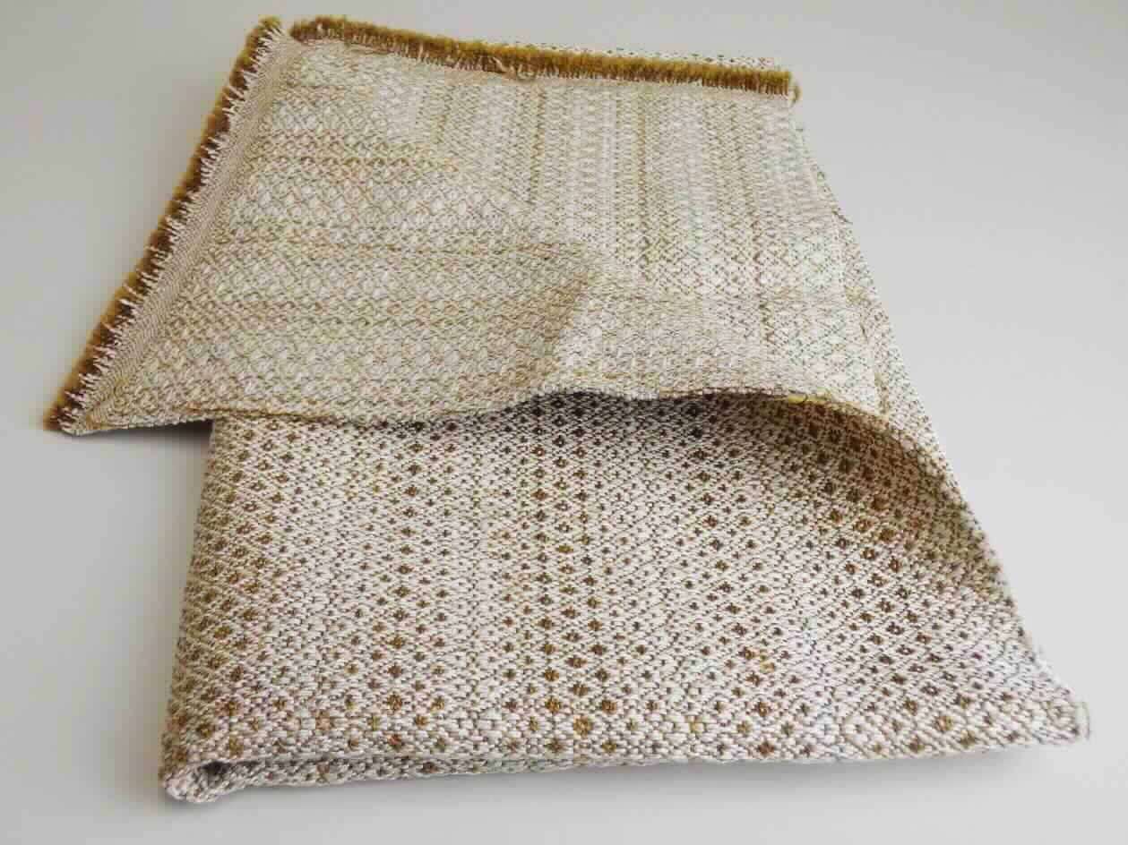 Gewebe, sog. Möbelbezugsstoff, Foto siehe Anlage, 
- als Meterware, mit einer Breite von mehr als 30 cm, 
- laut Untersuchungsergebnis: 
- - aus einem buntgewebten Jacquardgewebe, 
- - - mit braunmelierten Schussgarnen (Effektzwirn), bestehend aus zwei Garnen aus synthetischen Filamenten 
      (Polyester) und einem Garn aus synthetischen Spinnfasern (Polyester und Polyacryl), 
- - - mit weißen Kettgarnen (2-fach Zwirn) aus einem dünnen Einfachgarn aus künstlichen Spinnfasern (Viskose) 
      und einem dicken Einfachgarn aus künstlichen (Viskose) und synthetischen (Polyester) Spinnfasern und 
      Leinen, 
- - mit einem Gesamtanteil an: 
- - - künstlichen Spinnfasern (Viskose) von 46 GHT, 
- - - synthetischen Spinnfasern (Polyester- und Polyacryl) von 42,5 GHT, somit keine Ware der Position 5512, 
- - - synthetischen Filamente (Polyester) von 6,5 GHT und 
- - - Leinen von 5 GHT, 
- - auf der Rückseite dünn, mit dem bloßen Auge nicht wahrnehmbar mit Kunststoff bestrichen.

"Gewebe aus künstlichen Spinnfasern, anderes als in den Unterpositionen 5516 11 bis 5516 44 genannte,
 buntgewebt"