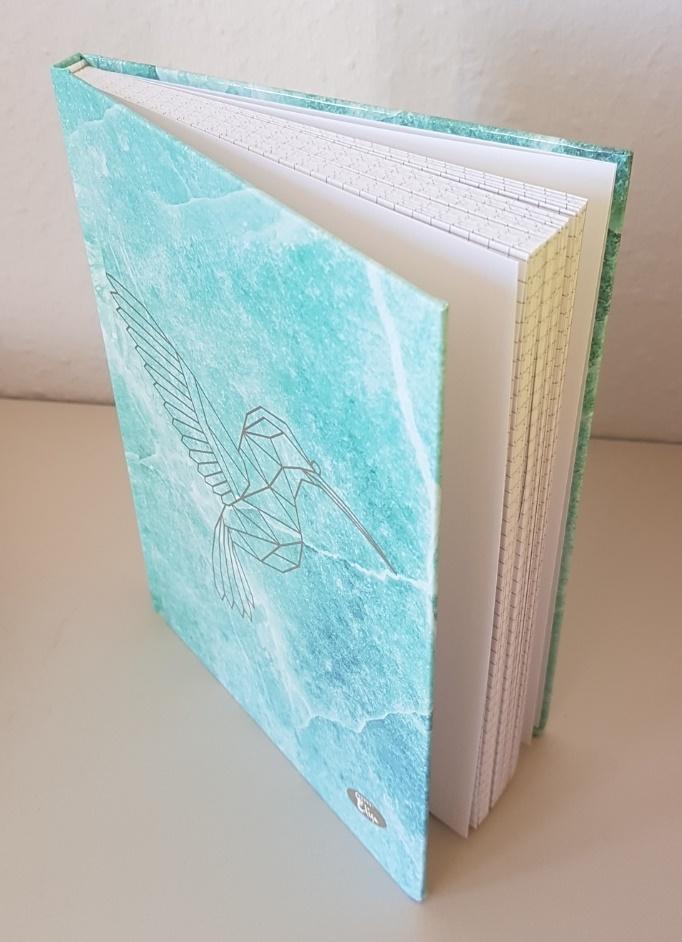 Es handelt sich um ein gebundenes Notizbuch (Format DIN A5), bestehend aus einem Einband aus mit einer klarsichtigen Kunststofffolie überzogenem Papier beklebter Pappe und 80 beidseitig kariert bedruckten Blättern aus Papier, z. B. zum handschriftlichen Eintragen von persönlichen Ereignissen oder Notizen. An der oberen und unteren Kante des Buchrückens ist das Erzeugnis jeweils mit einem weißen Kapitalband aus Spinnstoffen versehen. Der Vorderdeckel zeigt schauseitig im Wesentlichen die stilisierte Abbildung eines Kolibris.
 
 Abbildung siehe Anlage.
 
 Derartige Waren gehören als "Notizbücher, ohne Kalendarium, aus Papier oder Pappe" zur Codenummer 4820 10 30 00 0 des Zolltarifs.