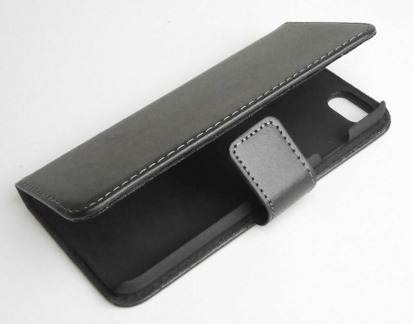 Etuiähnliches Behältnis, sog. Echtledertasche Apple iPhone 7, Foto siehe Anlage,
- mit einer Außenseite aus Leder (laut Antrag Rindsleder),
- seitlich aufklappbar; mit einer Lasche mit Magnetverschluss, 
- an der linken Innenseite mit einem großen offenen Einsteckfach sowie zwei weiteren Einsteckfächern im
  Scheckkartenformat ausgestattet,
- an der rechten Innenseite mit einer Schale aus Kunststoff als Halterung für ein Mobiltelefon, die an einer
  Schmalseite die Außenseite bildet, 
- mit Aussparungen für die Kameralinse und zur Bedienung des Mobiltelefons versehen,
- in den Abmessungen: ca. 14 cm (Höhe) x 7,5 cm (Breite) x 1,5 cm (Tiefe),
- ohne Hinweise auf Handarbeit,
- dient dem Transport und der Aufbewahrung eines Mobiltelefons in einer Tasche oder Handtasche,
- verpackt in einer handelsüblichen Verkaufsumschließung.

"Etuiähnliches Behältnis, Taschen- oder Handtaschenartikel, mit Außenseite aus Leder, nicht handgearbeitet"