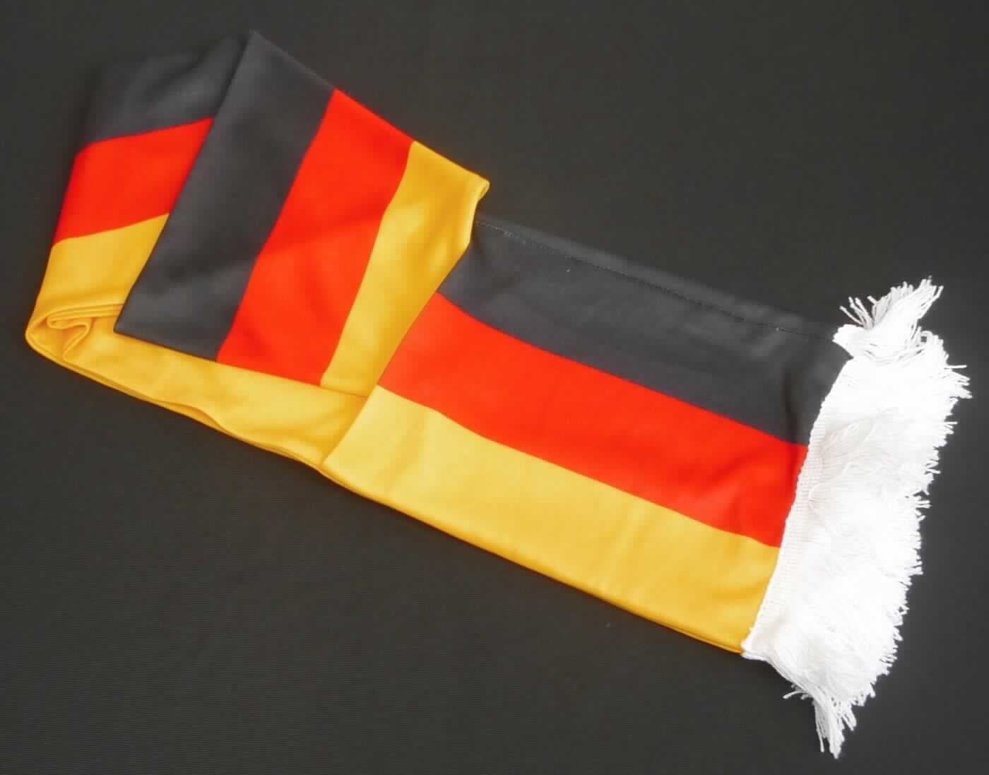 Schal, sog. Fanschal "Pockets" Deutschland, Art. 08971022-00000, in Erwachsenengröße, Foto siehe Anlage,
- rechteckig, in den Abmessungen von ca. 170 cm x 16 cm,
- aus ca. 0,5 mm, bedruckten Gewirken aus laut Antrag 100 % Polyester (synthetische Chemiefasern),
- schlauchförmig; durch Zusammennähen konfektioniert,
- an den Enden mit zwei aufgesetzten, offenen "Taschen", 
- an den Schmalseiten mit angesetzten Fransen.

"Anderes konfektioniertes Bekleidungszubehör (Schal), aus Gewirken"