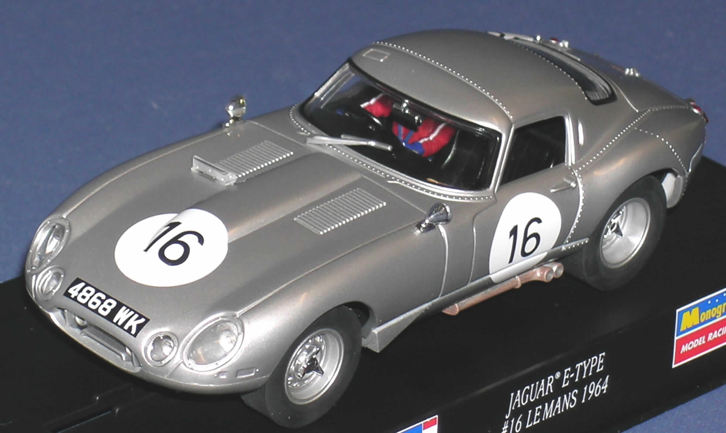 Erkennbares Teil eines elektrischen Auto-Rennspiels, das den Charakter eines Gesellschaftsspiels hat, sog. Jaguar-E-Type Lightweight Racing, Art.-Nr. 08359.

Bei der Ware handelt es sich um ein ca. 14 cm x 5 cm x 4 cm großes, silberfarbenes Modell eines Rennautos aus Kunststoff, im Maßstab 1:32, mit Motor und drehbaren Rädern mit Gummibereifung.
Das Modell wird auf elektrischen Auto-Rennbahnen (sog. slotracing-Bahnen) betrieben.

Das Auto dient der Unterhaltung von Personen und ist  - fixiert auf einem Kunststoffsockel - in einer durchsichtigen Kunststoffbox, die in eine bunt bedruckte Papphülle eingeschoben ist, verpackt.