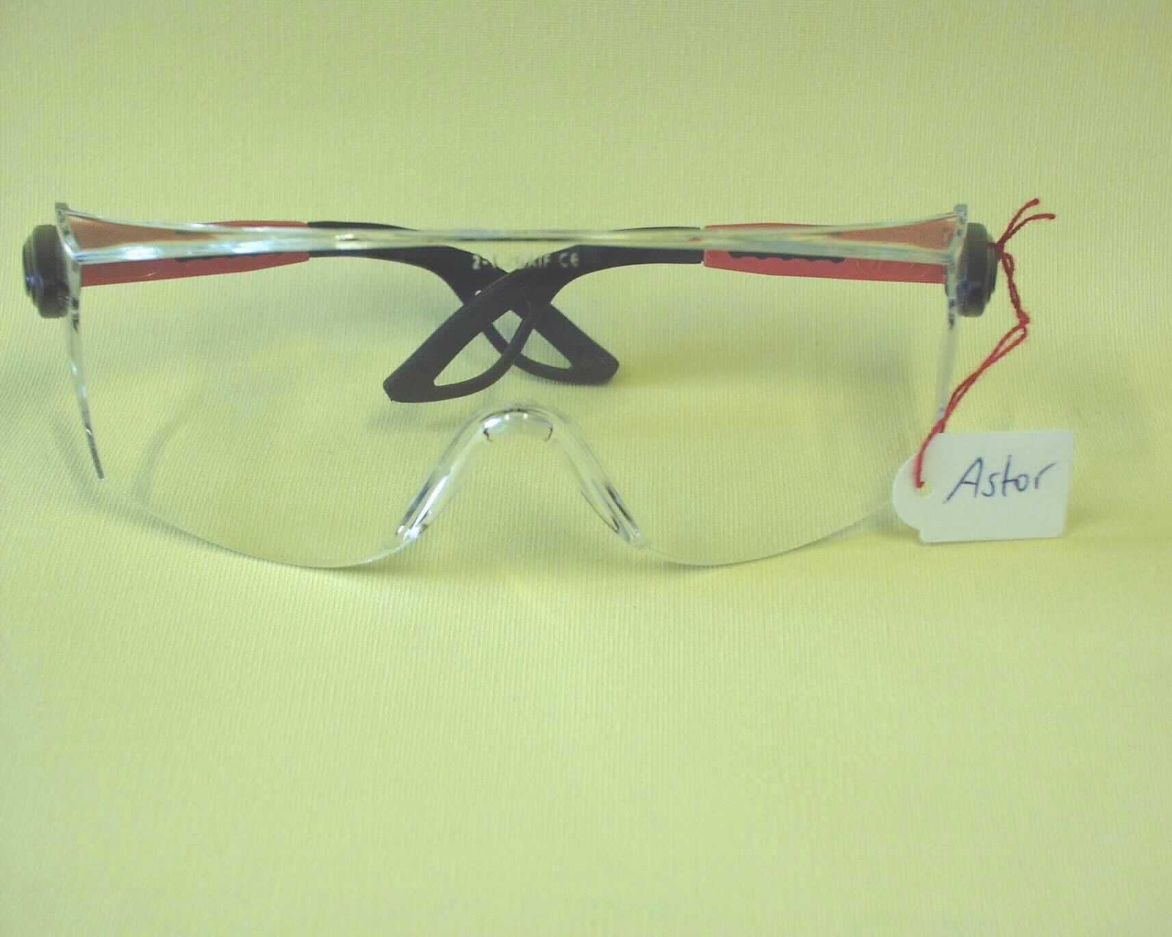 Schutzbrille, keine Sonnenbrille, sog. Schutzbrille Astor rot/schwarz/rot PC AS UV (Art.-Nr. 9110 105), im Wesentlichen bestehend aus einer ca. 19 cm breiten und zwischen ca. 3 bis 6 cm hohen, gewölbten Kunststoffscheibe mit Aussparung für die Nase, an der zwei ausziehbare Brillenbügel aus Kunststoff befestigt sind (äußere Form siehe Abbildung). Die Kunststoffscheibe ist an den Seiten auf einer Länge von je ca. 3 cm stark abgeschrägt. Die Ware, die in einer Kunststofftüte verpackt ist, dient dem Schutz der Augen bei Arbeiten unterschiedlicher Art.