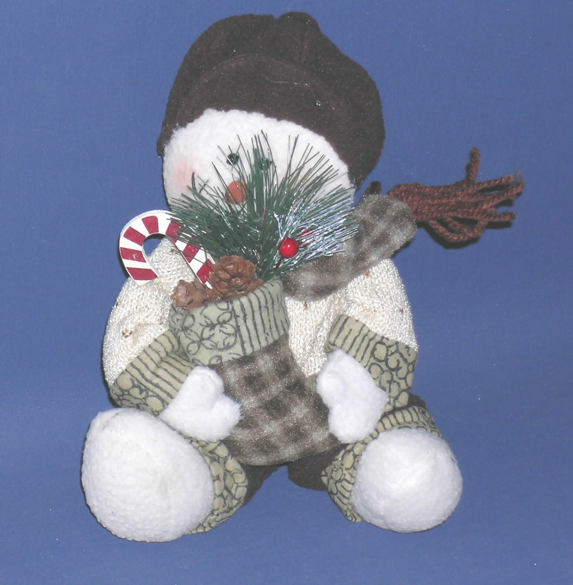 Puppe, Nachbildung eines Menschen darstellend (mittelbar), bekleidet, aus anderen Stoffen als aus Kunststoff, keine handgearbeitete dekorative Puppe in für das Ursprungsland charakteristischer Volkstracht, sog. Schneemann mit weihnachtlichem Flair.
Es handelt sich um einen ca. 19 cm großen, sitzenden Plüschschneemann aus weichem Material mit lachendem Gesicht, der mit Hose, Jacke, Schal und Schirmmütze bekleidet ist. In den Armen hält er eine Weihnachtssocke, die mit Zuckerstab, Tannenzapfen und einem mit Kugeln geschmückten Tannenzweig gefüllt ist. Der Schneemann ist im Gesäßbereich mit schwererem Material (Sand) gefüllt, so dass er in seiner sitzenden Position verharrt. Arme, Beine und Kopf sind aufgrund des Materials beweglich.
Trotz der weihnachtlichen Aspekte hat die Ware einen eigenen Gebrauchswert als Dekorationspuppe.

Bild der Ware im Internet unter http://europa.eu.int/comm/taxation_customs/dds/de/ebticau.htm