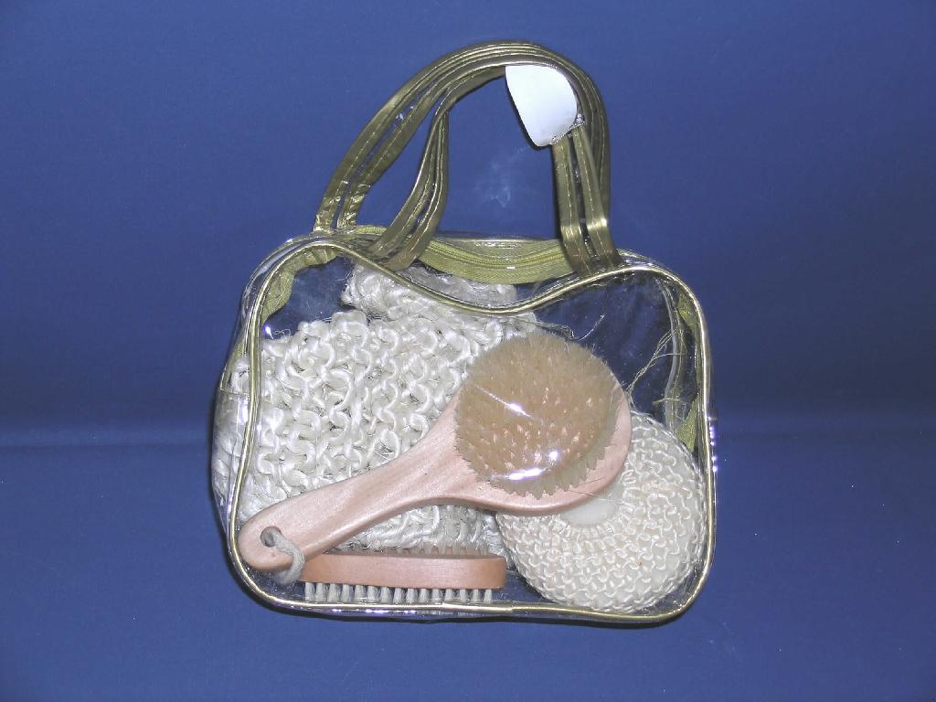 Reisezusammenstellung zur Körperpflege (Hautmassage, Körperreinigung), Art.-Nr.: 38006, bestehend aus einem Waschhandschuh aus Sisal (L x B = 23 x 15 cm) in Form eines Fäustlings, einem Schwamm, bestehend aus einem zylindrischen Schaumstoffzuschnitt mit einer Ummantelung aus Sisalgewirke (H x D = 6 x 9 cm), einer Körperbürste mit einer Fassung aus Holz mit Aufhängeschlaufe aus Spinnstoff und darin eingelassenen, einen Kreis bildendenden, geschmeidigen Borstenbüscheln (L x B = 18,3 x 7,8 cm) und einer Hand- bzw. Nagelbürste aus Holz mit einer Reihe Borstenbüscheln auf einer Seite und mehreren Reihen auf der anderen Seite (L x B = 9,5 x 1,3 cm). Die Waren zur Körperpflege sind in einer durchsichtigen Kunststofftasche (L x B x H = 22 x 7,5 x 15 cm) mit zwei Tragehenkeln, Reißverschluss und goldfarbener Umrandung verpackt.

1 Abbildung