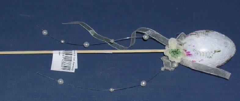 Osterfestartikel, sog. Kunststoff-Ei auf Stecker.
Es handelt sich um einen ca. 6 cm großen Hohlkörper aus Kunststoff auf einem ca. 29 cm langen Holzstab, in Form eines Ostereies, das mit weißer Spitze überzogen ist. Die Spitze ist ornamentartig mit grünen und rosafarbenen Farbpigmenten versehen. Unterhalb des Eies sind zwei künstliche Blüten, ein weißes Band und ein Perlenband auf einer Kunststoffschnur am Stab angebracht. 
Die Ware dient als Dekorationsartikel zur traditionellen Ausgestaltung des Osterfestes.
Ein Bild der Ware ist im Internet unter http://ec.europa.eu/taxation_customs/dds/ebticau_de.htm zu finden.