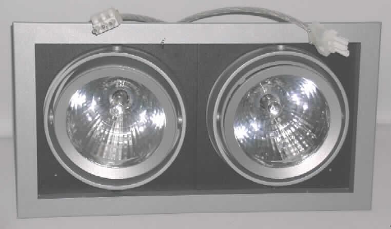 Elektrischer Beleuchtungskörper, anderweit weder genannt noch inbegriffen, als Decken-/Wandleuchte von der mit Gasentladungslampen verwendeten Art, aus unedlem Metall, nicht handgearbeitet, sog. Zwilllingsstrahler, Art. Nr. 9700077, im Wesentlichen bestehend aus einem ca. 46 x 24 x 21 cm großen Metallgehäuse mit vier Metallstegen für die Decken-/Wandbefestigung, zwei schwenkbaren Strahlern mit Metallreflektor und Glasscheibe, bestückt mit jeweils einer Halogendampflampe (35 W), elektrischer Verkabelung sowie Vorschaltgerät. 
Die Leuchte ist zum Einbau bestimmt und dient der Beleuchtung von z .B. Geschäftsauslagen.  
Ein Bild der Ware ist im Internet unter http://ec.europa.eu/taxation_customs/dds/ebticau_de.htm  zu finden.