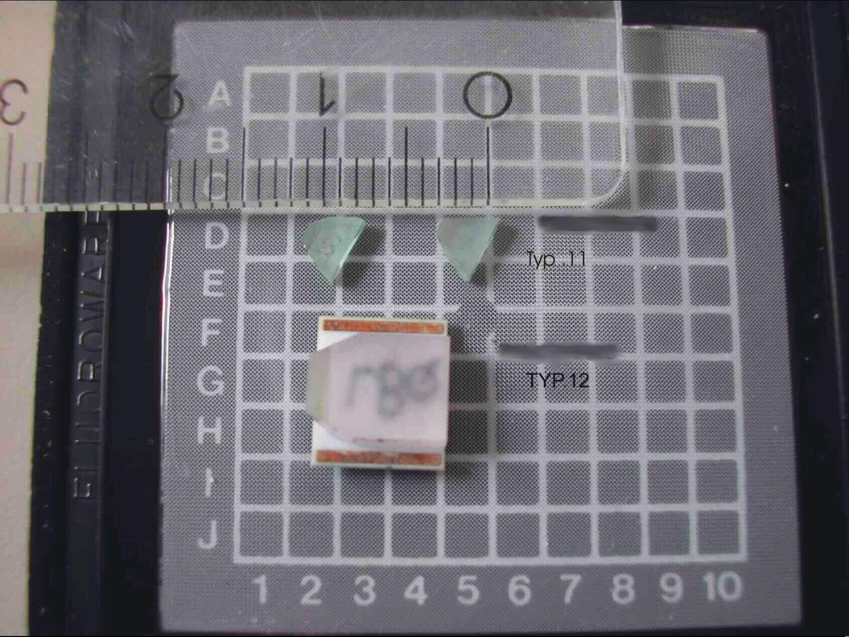 Optisches Element, nicht gefasst, anderes als in den Codenummern 9001 1010 00 0 bis 9001 9000 70 0 genannt, Kristall aus Chrom und Neodym dotiertem Yttrium-Aluminium-Granat (= Cr³+ Nd³+:YAG-), Typ 11, in bestimmter fast dreieckiger Form geschliffen (siehe Abbildung), mit einer Länge von ca. 3 mm, einer Höhe von ca. 1,25 mm und Breite von bis zu ca. 4 mm. Der Kristall selbst wird durch Licht einer bestimmten Wellenlänge angeregt und emittiert dadurch Laserlicht einer anderen genau definierten Wellenlänge.
Ein Bild finden Sie unter: http://europa.eu.int/comm/taxation_customs/dds/de/ebticau.htm
