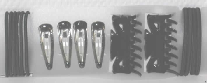 Haarspangen aus unedlem Metall in Form einer Warenzusammenstellung in Aufmachung für den Einzelverkauf, sog. "Haaraccesoire, Arikel-Nr. 049596".
Die Warenzusammenstellung besteht aus:
- vier ca. 4,5 cm großen, tropfenförmigen, leicht gebogene Haarspangen aus unedlem Metall, die mit gelartigem, braunem Farbüberzug mit Glitzerpartikeln versehen sind,
- zwei, ca. 6 cm großen Haarklammern aus schwarzem Kunststoff in Form von zwei mittels einer Metallfeder verbundenen, zueinander gebogenen Kämmen, und
- sechs 0,2 mm und vier 0,5 mm dicken, schwarzen Haargummis aus einem mit Spinnstoffgarnen umflochtenen, elastischen  Kautschukfaden, die an den Enden durch eine Hülse aus unedlem Metall zusammengefügt sind.
Keines der Erzeugnisse bestimmt den Charakter der Warenzusammenstellung, Ein charakterbestimmender Bestandteil ist nicht ermittelbar; die Haargummis überwiegen aufgrund ihrer Menge, die Haarspangen und -klammern weisen den höchsten Wert auf, so dass die Einreihung in die zuletzt genannte, der gleichermaßen in Betracht kommenden Positionen erfolgt. 
Innerhalb der Position 9615 bestimmen aufgrund der Menge und des Wertes die Haarclips aus unedlem Metall den Charakter der Warenzusammenstellung.
Die Erzeugnisse sind auf einer durchscheinenden Kunststoffkarte mit Aufhängeöse aufgesteckt und in einer klarsichtigen Kunststofftüte für den Einzelverkauf aufgemacht.
Ein Bild der Ware befindet sich im Internet unter http://ec.europa.eu/taxation_customs/dds/ebticau_de.htm.