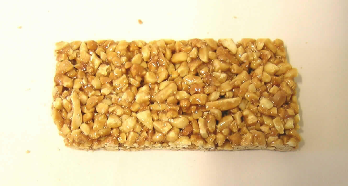 Erdnussriegel.

Antragsangaben (als zutreffend unterstellt): Krokant mit Erdnuss, Zutaten: Erdnüsse 66 %, Zucker, Glucose.

Untersuchungsergebnis der vorgelegten Warenprobe: ca. 10x4,5x1 cm großer Riegel aus zerkleinerten Erdnüssen, welche mit einer braunen Krokantschicht überzogen sind. Geschmack: süß, nach karamellisierten Erdnüssen, knusprig. Verpackung: einzeln in etikettierter Schlauchfolie verpackt, auszugsweise: "Nettogewicht 40 g, Erdnüsse 66 %".

Geröstete Erdnüsse, in anderer Weise zubereitet oder haltbar gemacht, in unmittelbaren Umschließungen mit einem Gewicht des Inhalts von 1 kg oder weniger.