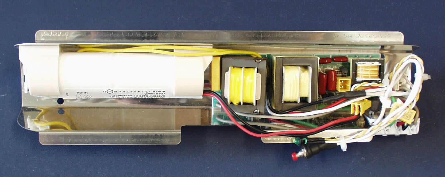 Erkennbares Metallteil für ein Leuchtschild (Rettungszeichenleuchte), nicht handgearbeitet  in Form eines Reflektorblechs mit elektrischer Ausstattung.
Es handelt sich um ein u-förmiges Reflektorblech mit dem Abmessungen 31 x 8,5 x 4,7 cm (L x B x H), das auf der Oberseite mit zwei Kontakten für eine 8 W Röhre ausgestattet ist. Darüber hinaus verfügt die Ware auf der Unterseite über die notwenige elektrische Ausstattung für die Stromversorgung durch das Leitungsnetz bzw. bei Notfällen durch einen integrierten Ni-Cd-Akkumulator. Eine anliegende Netzspannung wird durch eine Leuchtdiode sichtbar gemacht. 
Der industriell hergestellte Einsatz wird in das Gehäuse einer sog. Rettungszeichenleuchte zur Fluchwegkennzeichnung in Gebäuden eingesetzt, die auch bei Stromausfall für eine ausreichende Beleuchtung sorgt.