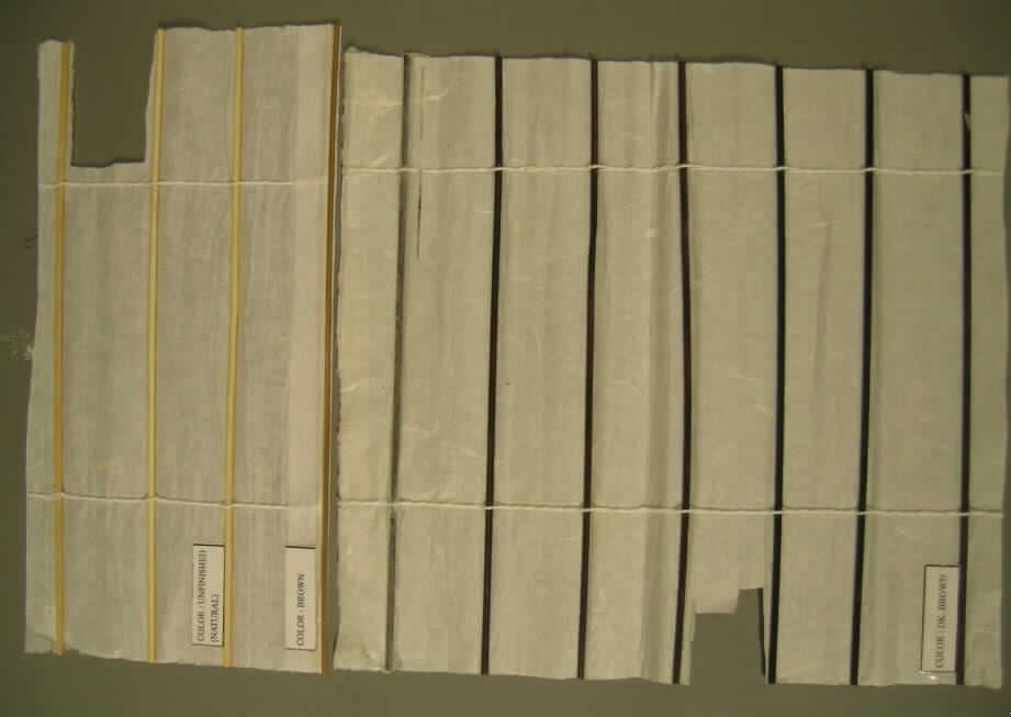 Vorhang, sog. Schiebevorhang "Rice", Art. 338282, siehe Foto,
- laut Antrag mit einer Breite von 60 cm und einer Länge von 245 cm; wird durch einen
  Probenabschnitt und Abbildungen veranschaulicht, 
- laut Untersuchungsergebnis aus einem 0,26 mm dicken, einfarbigen, zweilagigen, durch 
  Kleben miteinander verbundenen Flächenerzeugnis mit  
-- einer Seite aus einem mit Bindemittel verfestigtem Vliesstoff  aus überwiegend Polyester 
   (synthetische Chemiefasern) und 
-- der anderen Seite aus Papier,
-- der Vliesstoff bestimmt im Hinblick auf die Dicke und das Gewicht den Charakter des
   zweilagigen Flächenerzeugnisses,
- auf einer Seite in einem Abstand von etwa 4 cm mit aufgeklebten Stäbchen aus augen-
  scheinlich Rattan,
- laut Antrag am oberen Rand mit einem über die gesamte Breite angenähten Flauschband,
  am unteren Rand mit einer angeklebten Holzleiste.