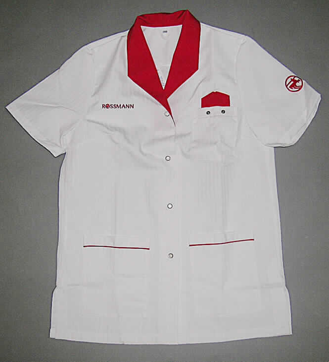 Jacke (Arbeitsjacke) für Frauen, sog. Schürzen, Kittel und andere Arbeits-und Berufskleidung, Größe 38 / 40, siehe Abbildung;
- aus 0,4 mm dicken, einfarbigen (weiß), strapazierfähigen Geweben aus lt. Antrag 
  65% Polyester (synthetische Chemiefasern) und 35% Baumwolle,
- über den Schritt, aber nicht über den halben Oberschenkel reichend (Rückenlänge: 81 cm),
  mit etwa 13 cm hoch reichenden Seitenschlitzen; aufgrund der geringen Länge kein Kittel 
  der Position 6211,
- mit einem kontrastfarbenen Umlegekragen,
- vorn mit einer durchgehenden Öffnung mit Druckknopfverschluss von rechts über links 
  (Frauenkleidung),
- mit einer aufgesetzten Brusttasche mit Druckknöpfen, an denen ein Namensschild ange-
  bracht werden kann; oberhalb der Tasche mit aufgenähten, kontrastfarbenen Gewebe-
  zuschnitten verziert, die ein Einstecktuch imitieren sollen,
- in Brusthöhe mit dem Firmennamen bestickt,
- mit kurzen Ärmeln, auf dem linken Ärmel mit einem Firmenlogo bestickt,
- mit zwei großen aufgesetzten Taschen unterhalb der Taille (u.a. somit keine Hemdbluse),
  mit kontrastfarbenen Paspeln,
- am unteren Rand durch Umschlagen und Festnähen gesäumt,
- insbesondere wegen des strapazierfähigen Materials, der Ausstattung und des einfachen, 
  zweckbestimmten Schnitts erkennbar dazu bestimmt, ausschließlich oder hauptsächlich 
  zum Schutz der Person und/oder der Kleidung bei der Ausübung einer beruflichen Tätigkeit 
  getragen zu werden.